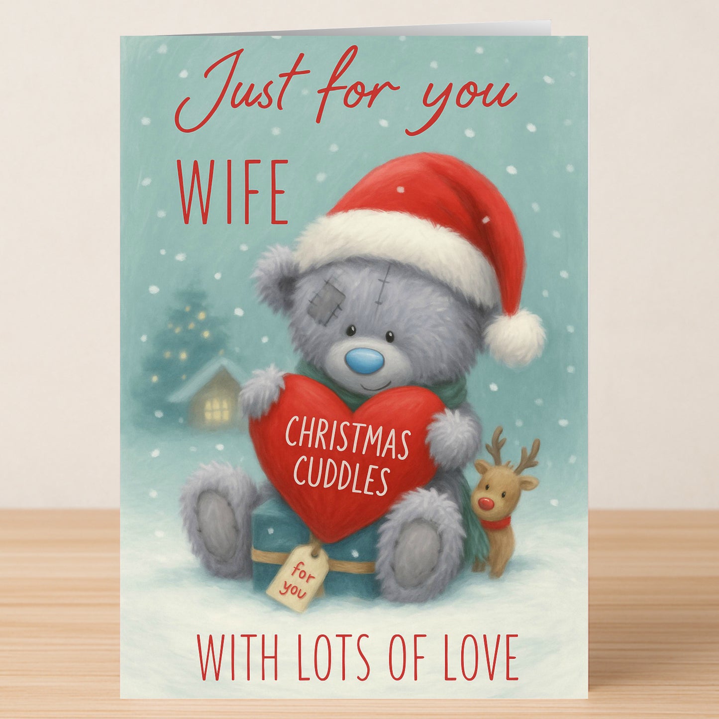 The Twisted Gifts Wife Bear Christmas Card features a teddy bear in a Santa hat with a heart labeled "Christmas Cuddles" and a reindeer, plus the message "Just for you wife, with lots of love." Sweet holiday card for your wife.