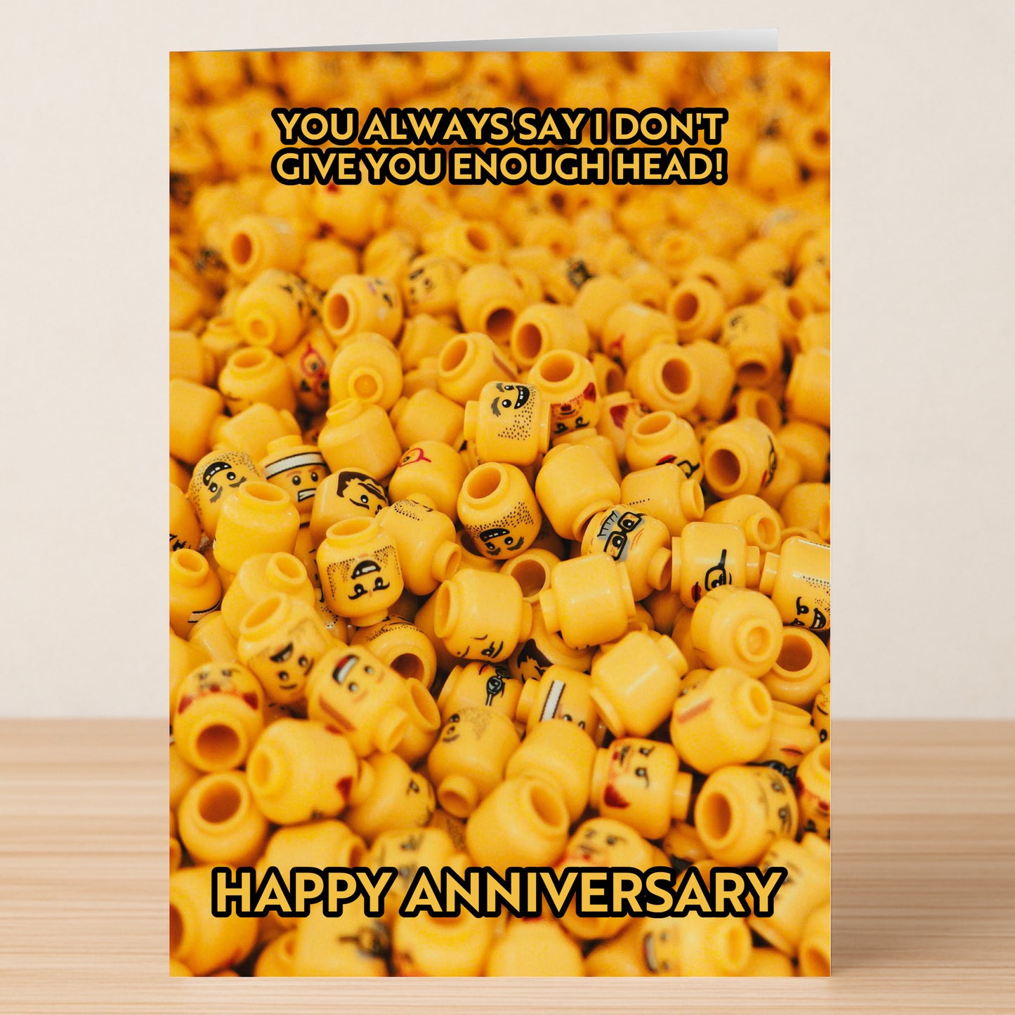 The Not Enough Head Funny Anniversary Card by Twisted Gifts features a pile of LEGO minifigure heads and the cheeky message, "You always say I don't give you enough head! Happy Anniversary." A hilarious and unique way to celebrate!.