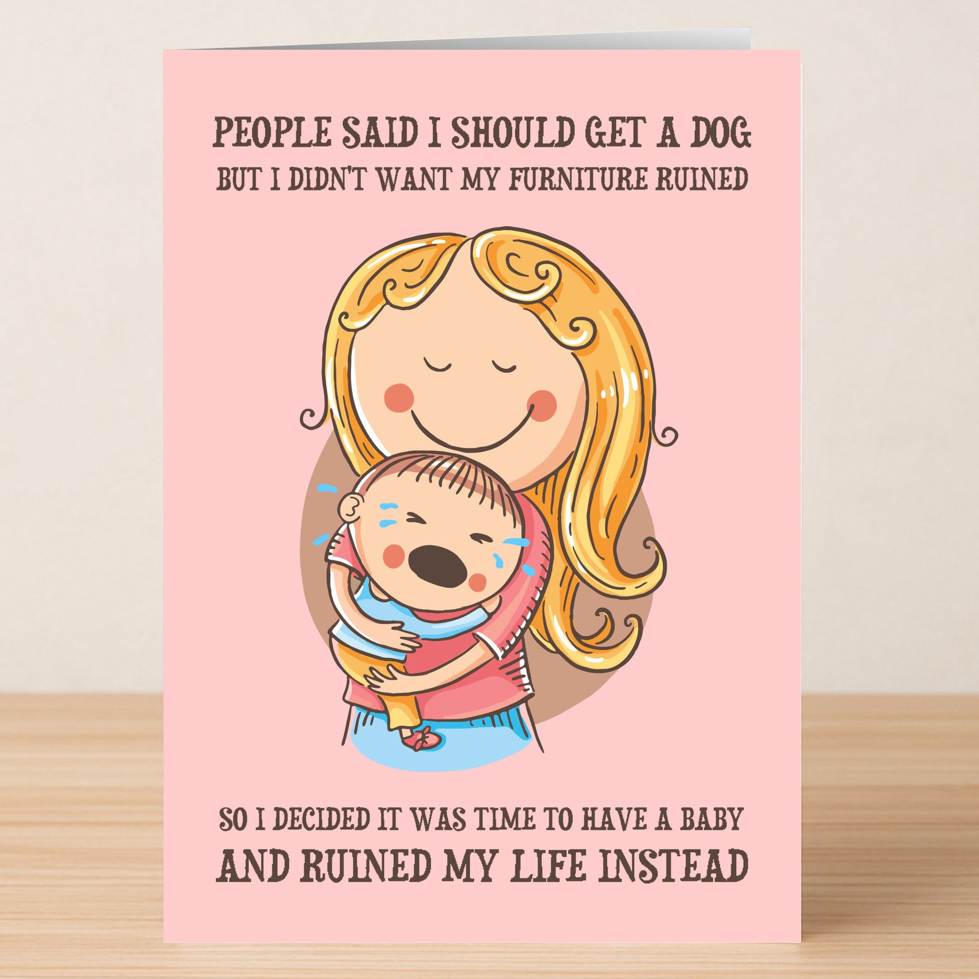 The Get A Dog Funny Greeting Card by Twisted Gifts features a smiling woman holding a crying baby, joking that she chose a baby over a dog and it "ruined my life instead"—a hilarious pick for dog lovers with a sense of humor.