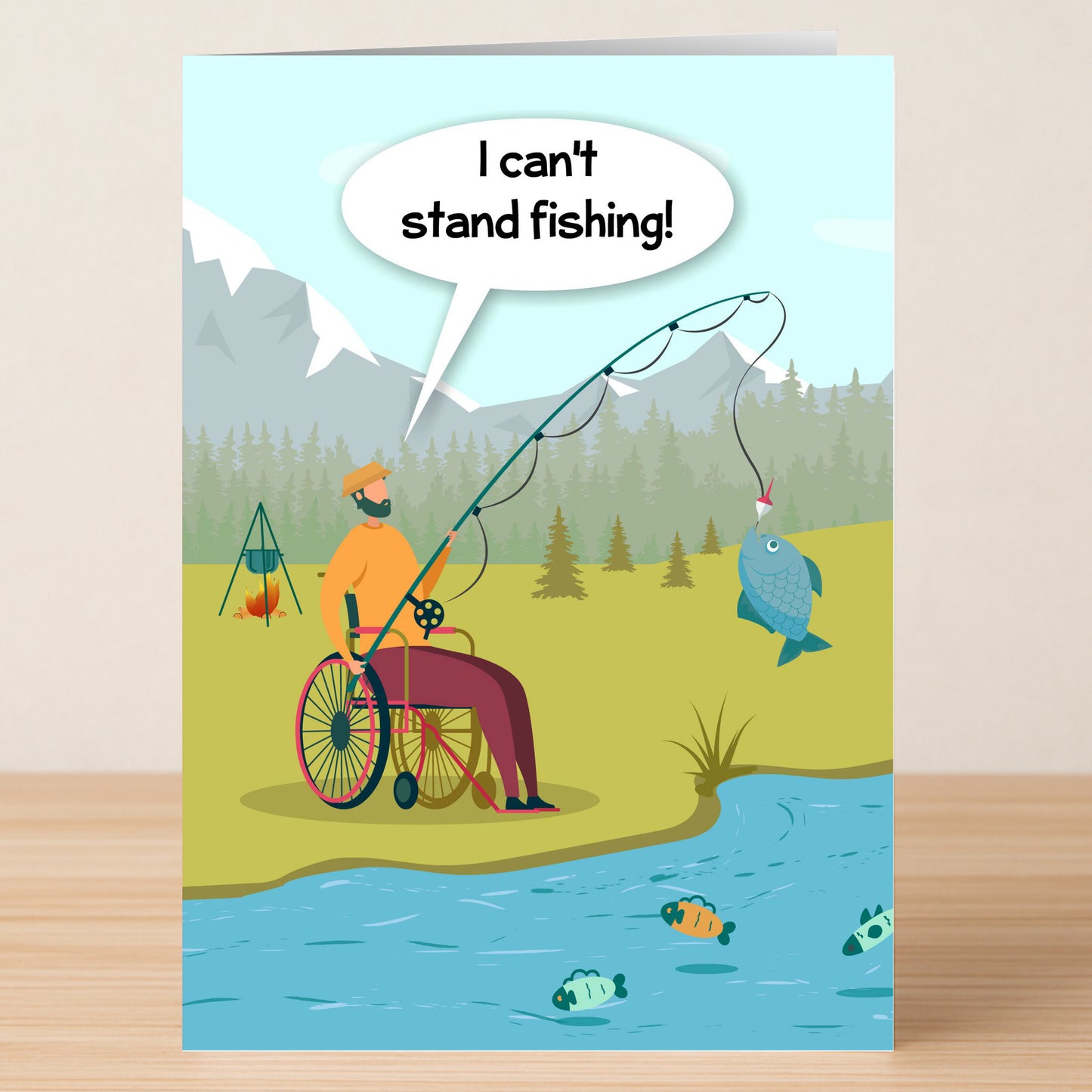 A fishing enthusiast in a wheelchair reels in a catch by the river, joking, "I can't stand fishing!"—the perfect witty message featured on Twisted Gifts' Can't Stand Fishing Funny Greeting Card.