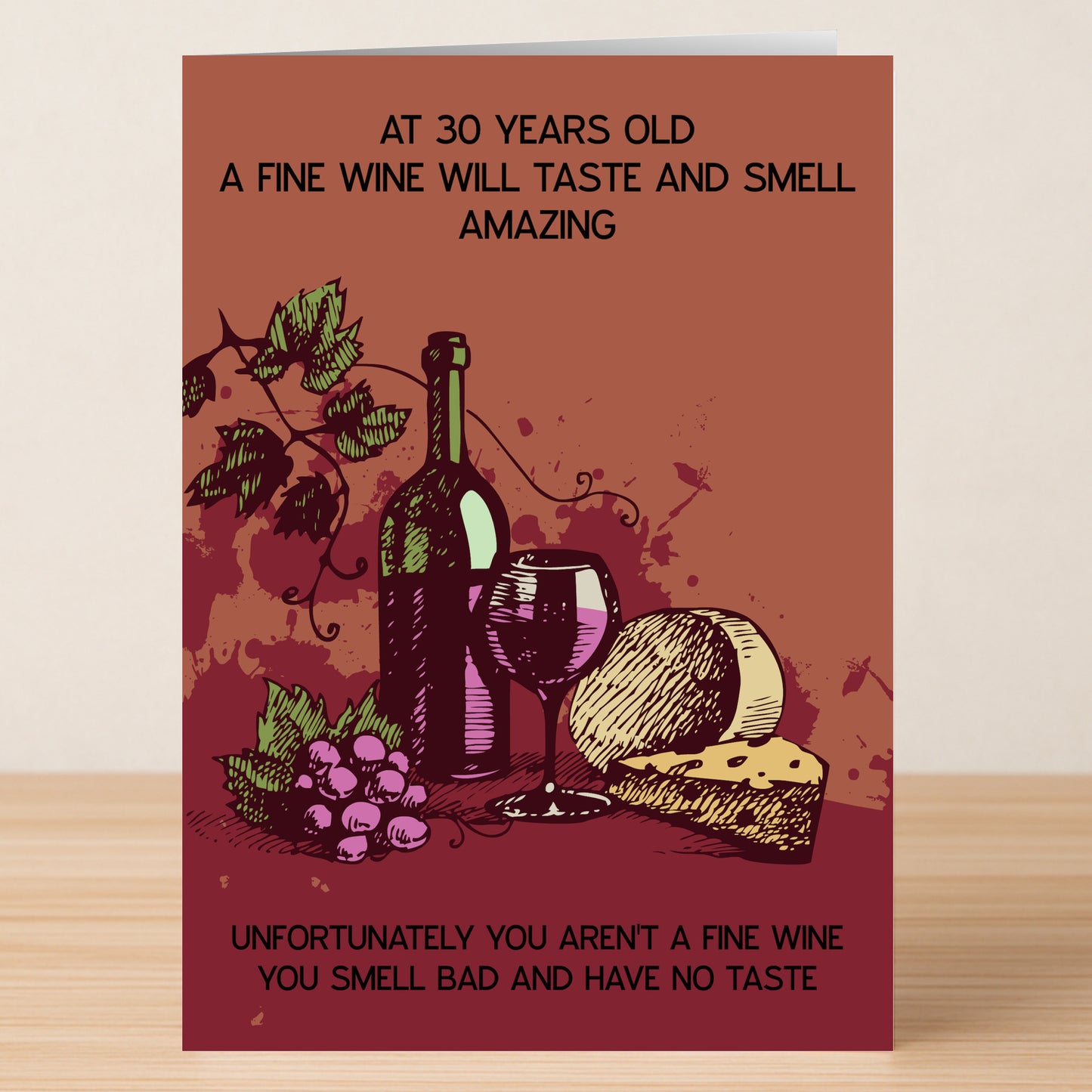 The Fine Wine – Insulting 30th Birthday Card by Twisted Gifts features wine, cheese, and grapes on a wooden surface with the funny message: "At 30 a fine wine tastes amazing. Unfortunately you aren't a fine wine.