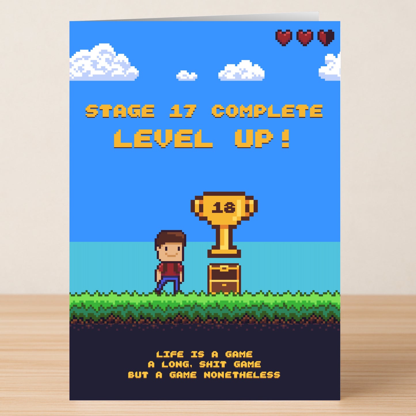 Twisted Gifts' nonethelessI – Funny 18th Birthday Card features retro 8-bit graphics, a trophy with "18," and the message: "Stage 17 complete. Level up! Life is a game, a long, shit game but a game nonetheless." Perfect for gamer humor.