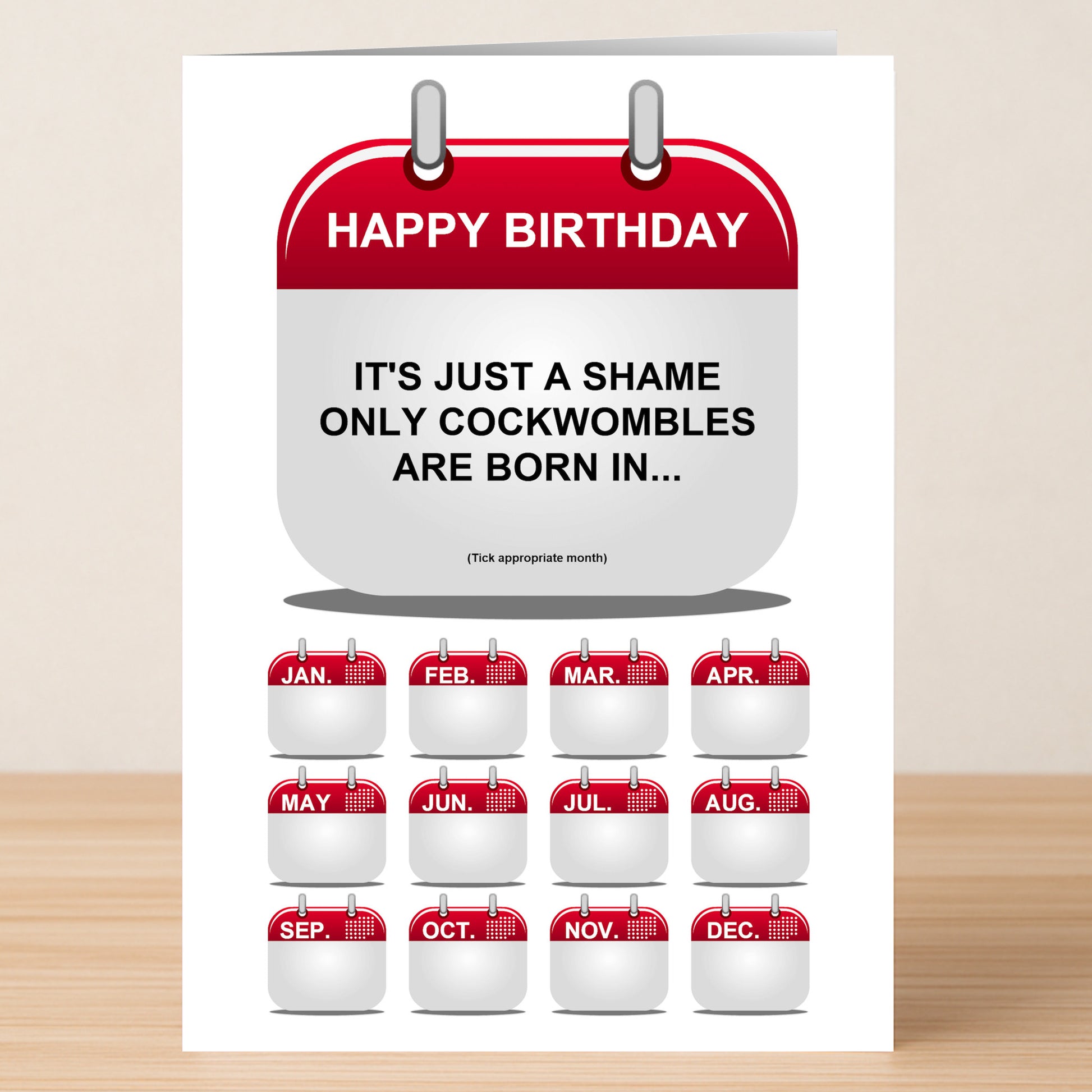 The Cockwomble Rude Birthday Card by Twisted Gifts features a hilarious message—"HAPPY BIRTHDAY. IT'S JUST A SHAME ONLY COCKWOMBLES ARE BORN IN..." with checkboxes for all months. Perfect for anyone who enjoys edgy humor!.