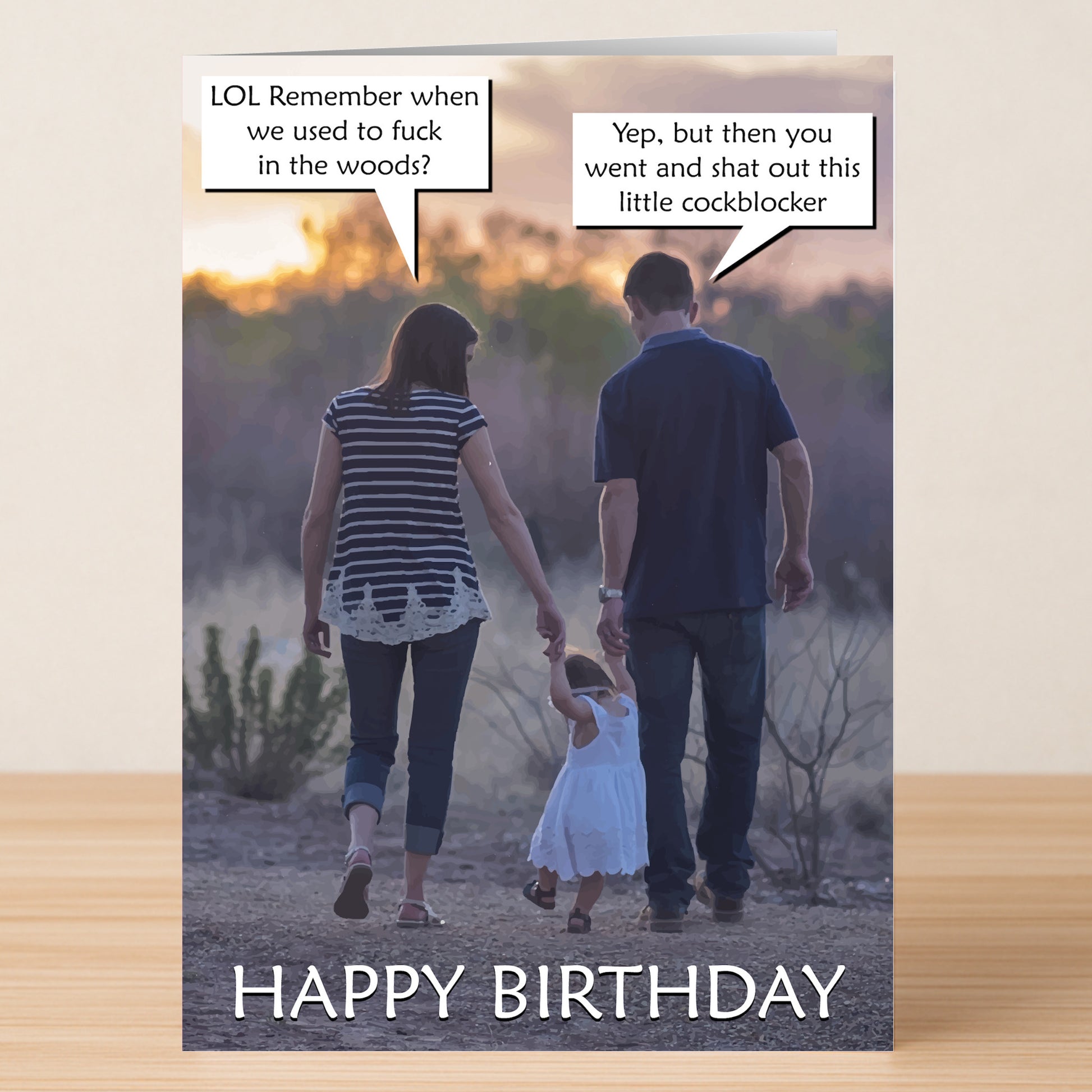 A man and woman hold hands with a child at sunset, cheeky speech bubbles overhead. “HAPPY BIRTHDAY” text below makes this Cockblocker Rude Birthday Card by Twisted Gifts the perfect funny birthday card for a good laugh!.