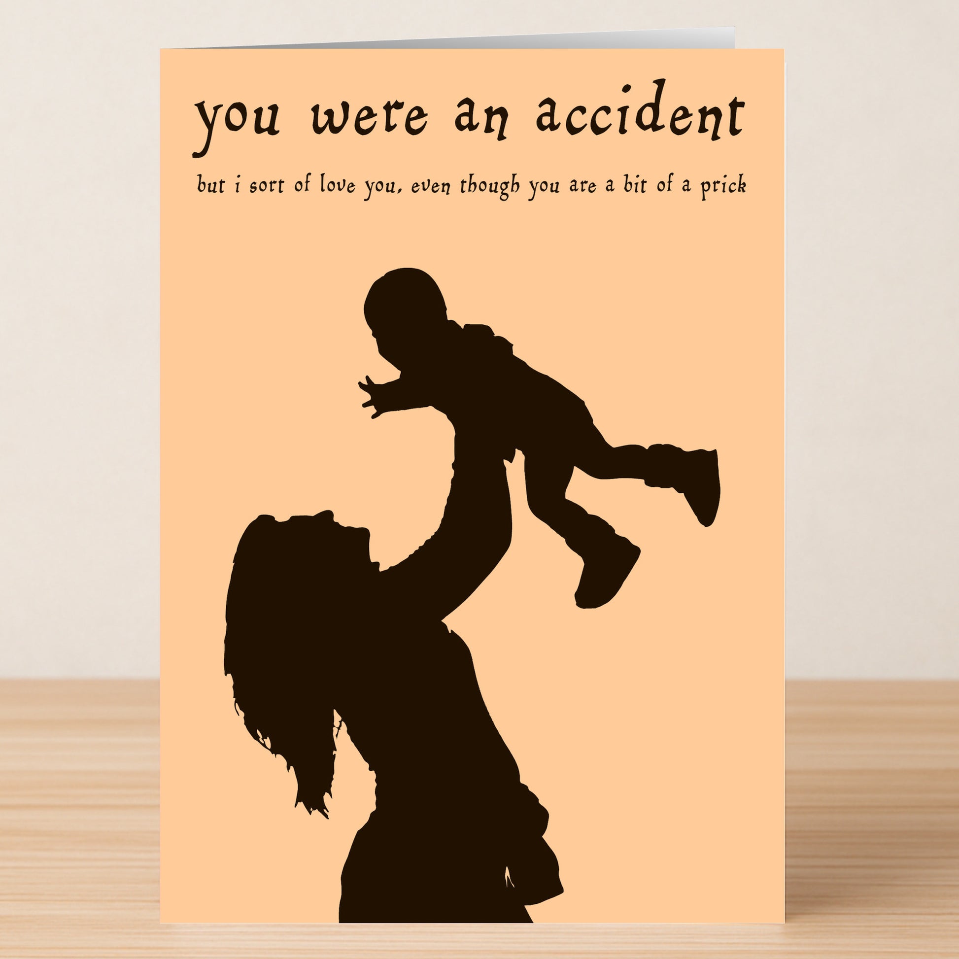 The Twisted Gifts Accident Insulting Birthday Card showcases a funny silhouette of an adult lifting a child with the message, "you were an accident but i sort of love you, even though you are a bit of a prick.
