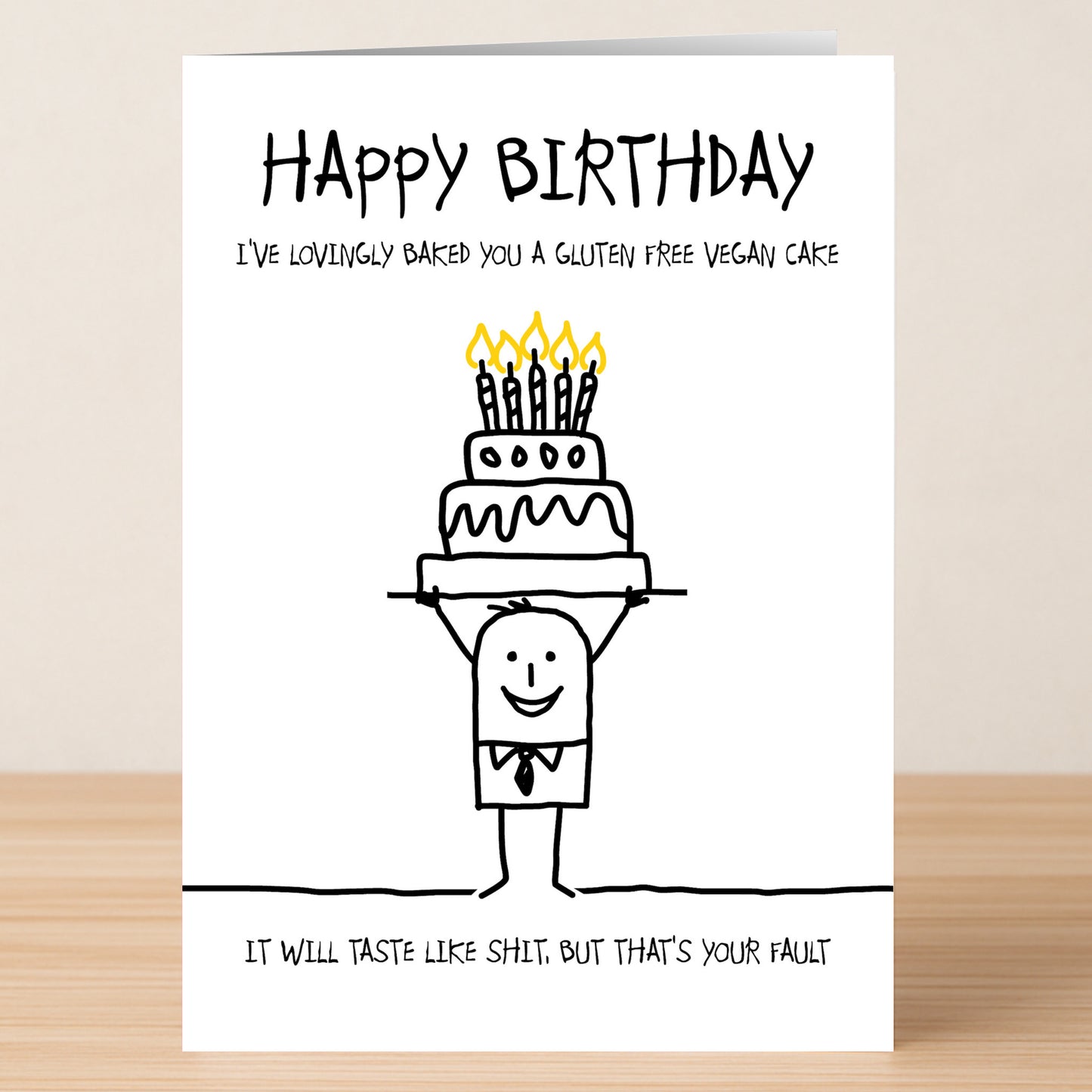 The Twisted Gifts "GFV Cake Insulting Birthday Card" features a stick figure with a cake and the funny message: "I've lovingly baked you a gluten free vegan cake. It will taste like shit. But that's your fault." Perfect for birthdays!.