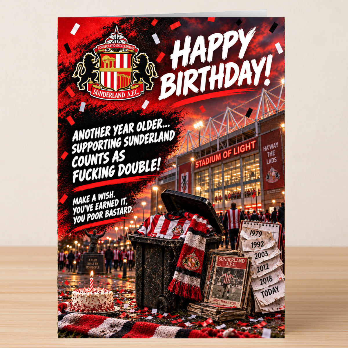 Sunderland – Funny Birthday Card featuring the Sunderland A.F.C. stadium, a trash can of memorabilia, and a cake reading: “Happy Birthday! Another year older... supporting Sunderland counts as fucking double!”.