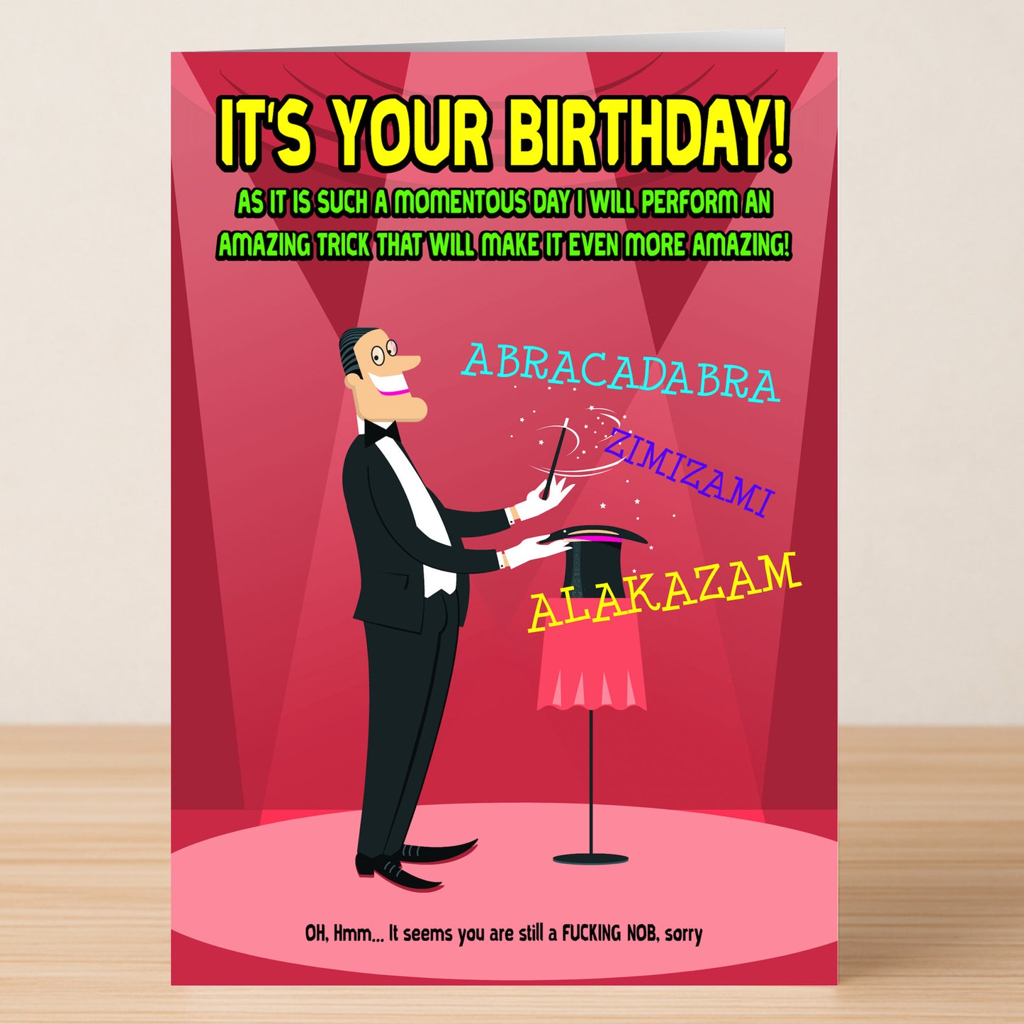 A cartoon magician from Twisted Gifts' Magic Insulting Birthday Card performs tricks with words like "ABRACADABRA!" and bold text shouts, "IT'S YOUR BIRTHDAY!"—the perfect sarcastic humor for any birthday.
