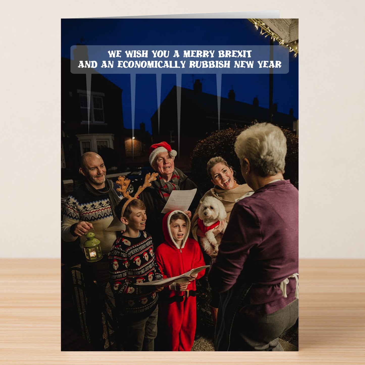 The Merry Brexit Funny Christmas Card by Twisted Gifts features festively dressed carolers singing outside a house with the caption, "We wish you a merry Brexit and an economically rubbish new year." Perfect for fans of Brexit humor.