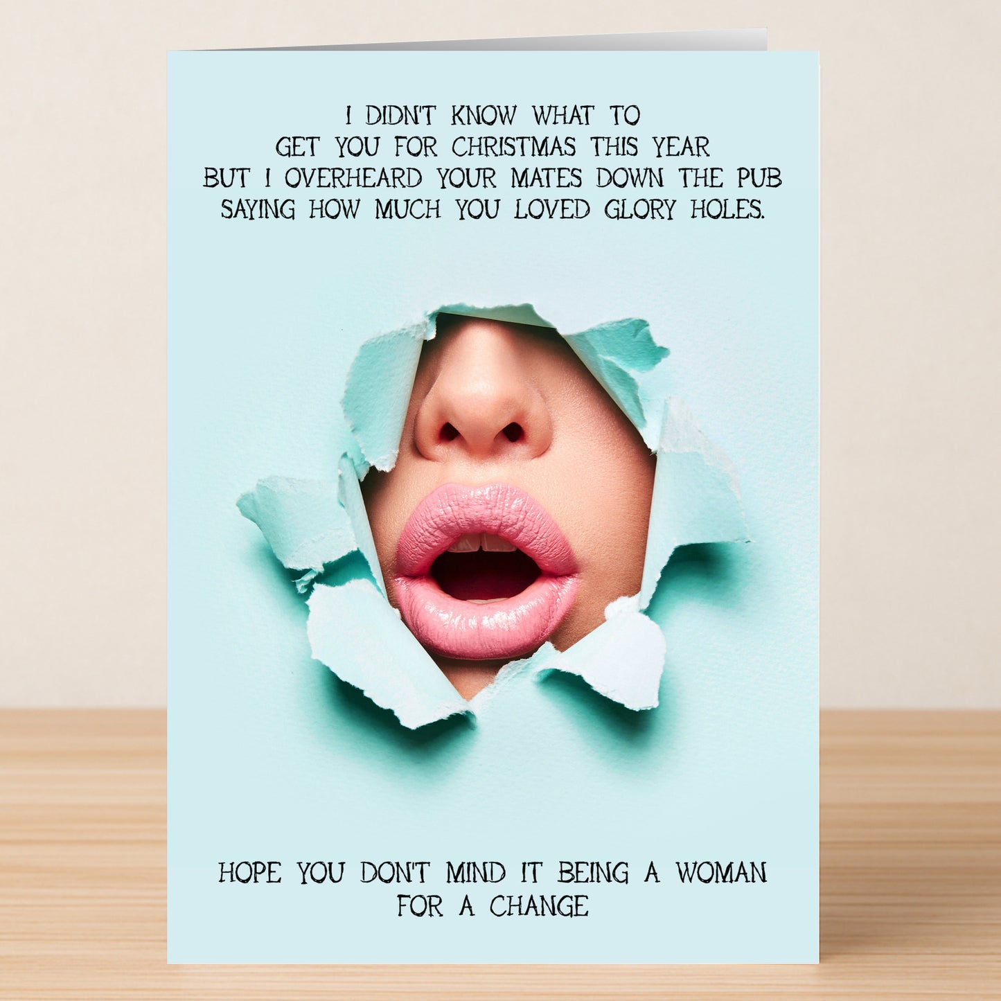 The Glory Hole Rude Christmas Card by Twisted Gifts features lips and nose through torn blue paper with cheeky Christmas pub banter—an unforgettable festive card for anyone who loves a memorable, humorous holiday greeting.
