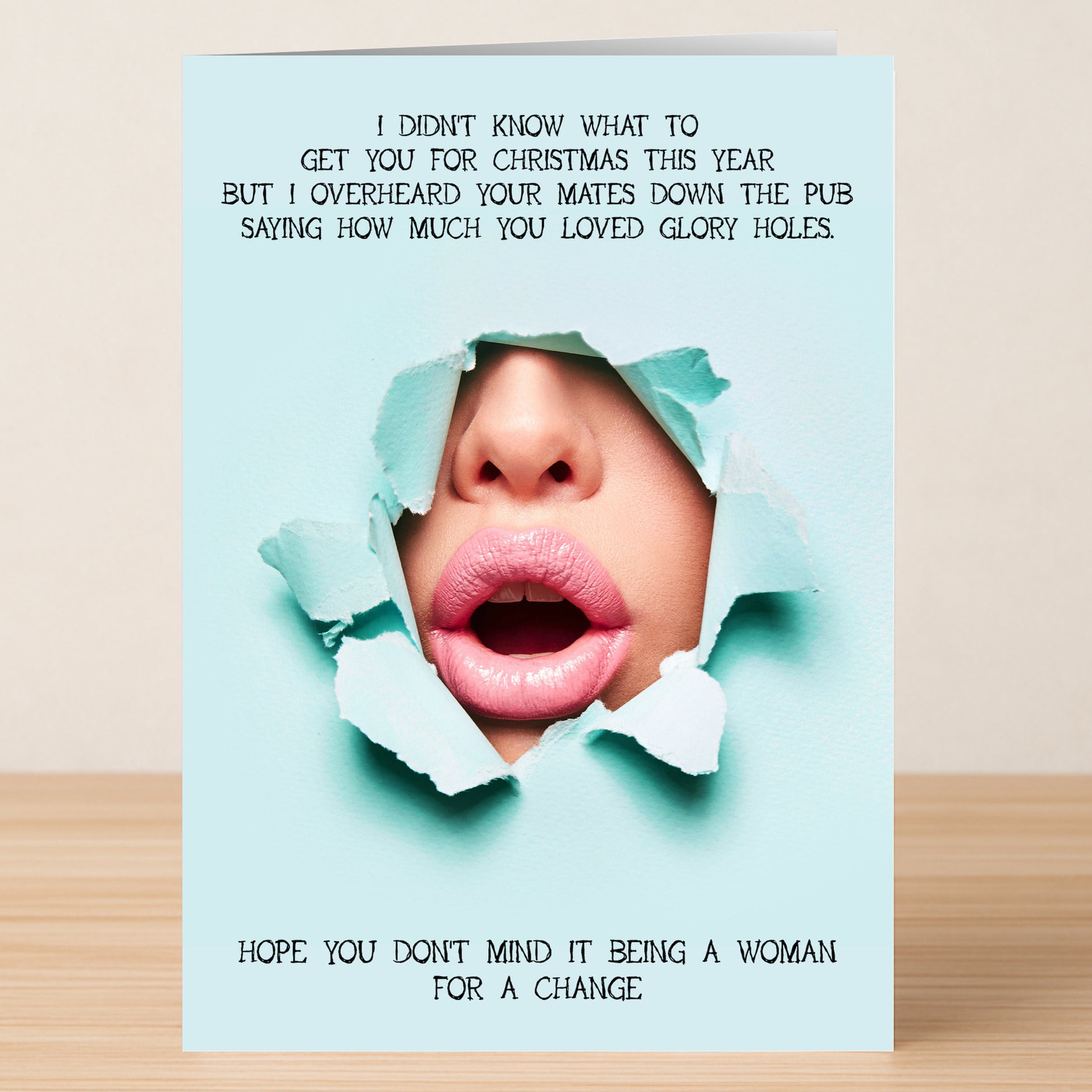 The Glory Hole Rude Christmas Card by Twisted Gifts features lips and nose through torn blue paper with cheeky Christmas pub banter—an unforgettable festive card for anyone who loves a memorable, humorous holiday greeting.