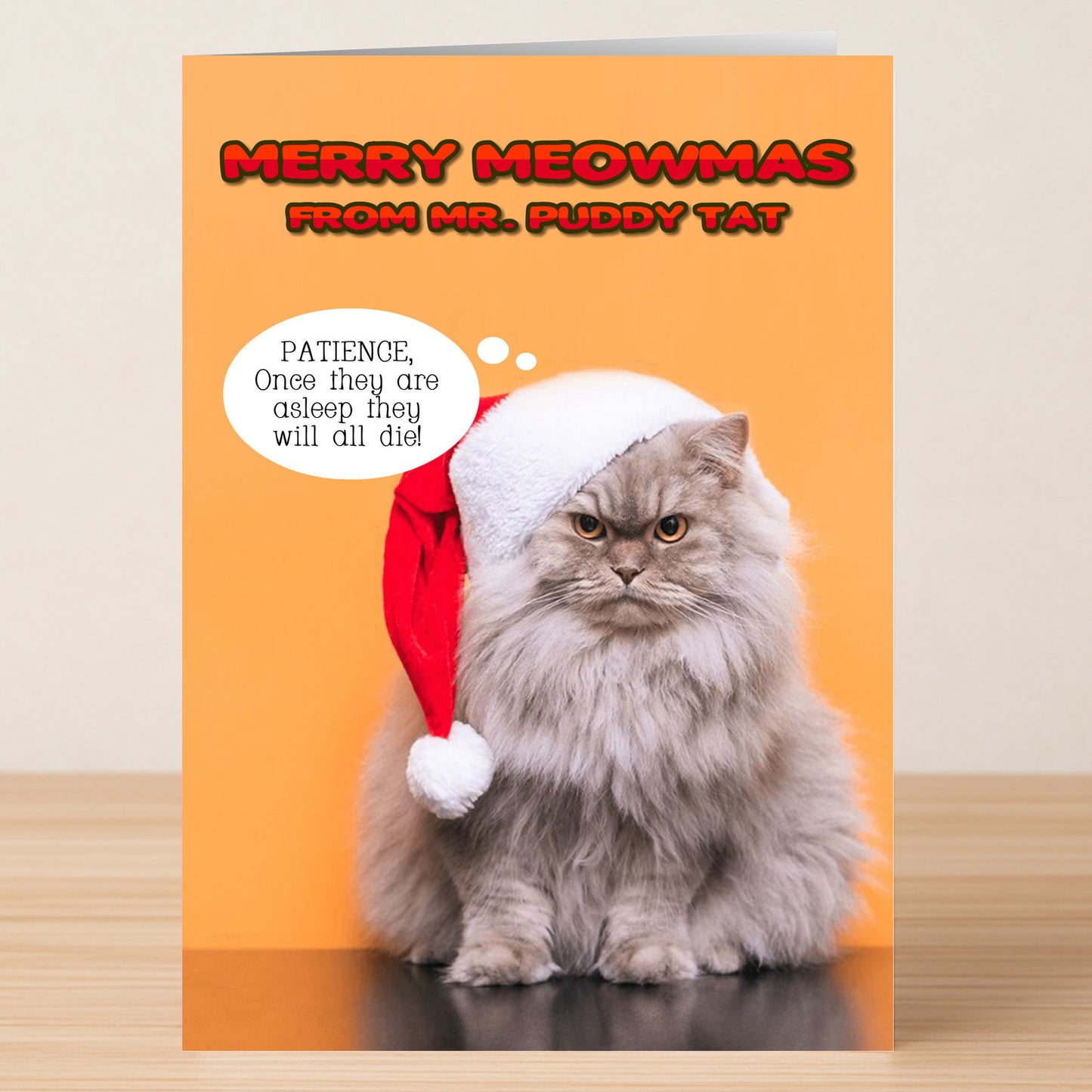 The Mr. Puddy tat Funny Christmas Card by Twisted Gifts features a fluffy gray cat in a Santa hat on an orange background with "Merry Meowmas from Mr. Puddy Tat"—a quirky holiday card to spread Christmas cheer!.