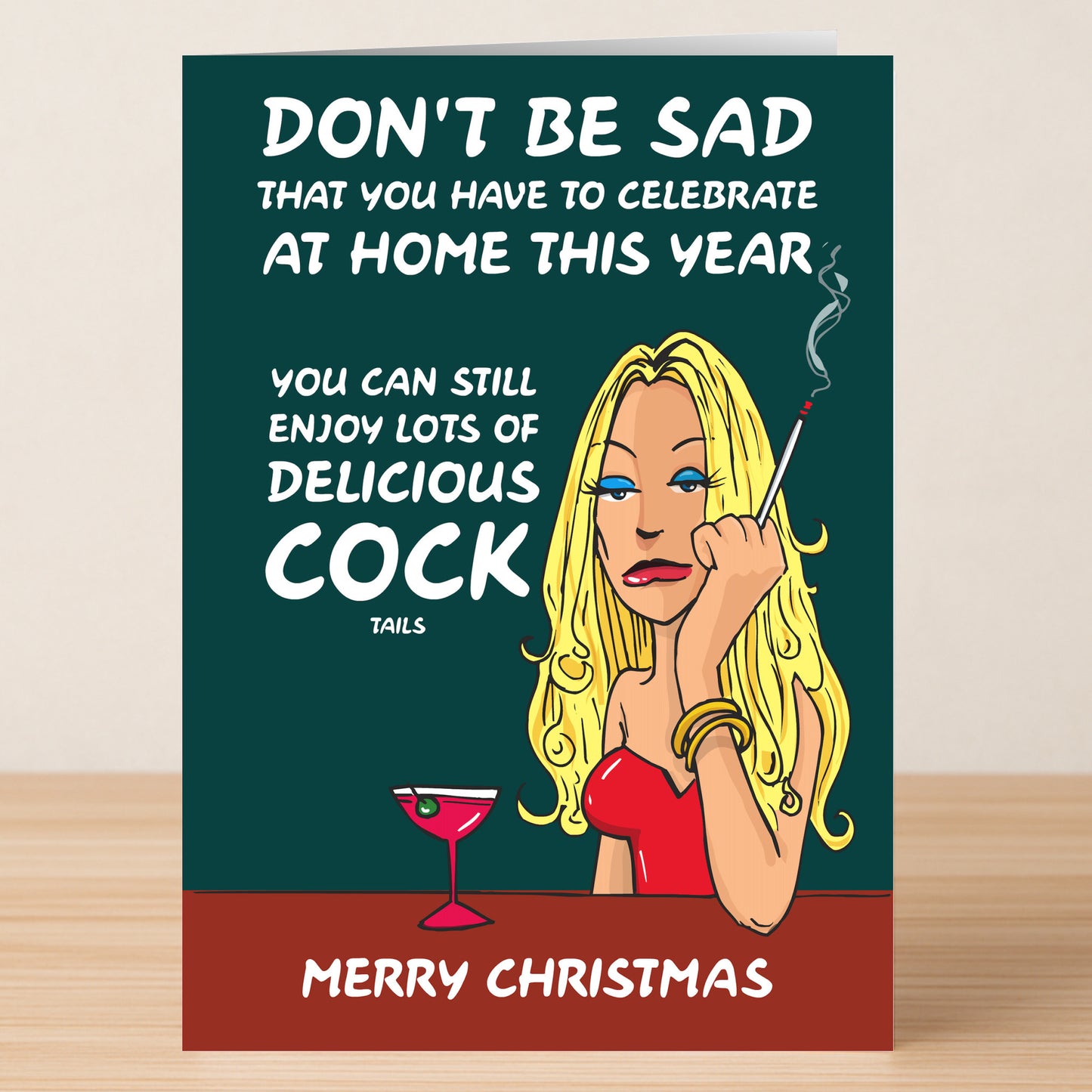 The Cock Tails Rude Christmas Card by Twisted Gifts features a cartoon woman in a red dress with a cigarette and martini, adding witty holiday humor about celebrating Christmas at home.