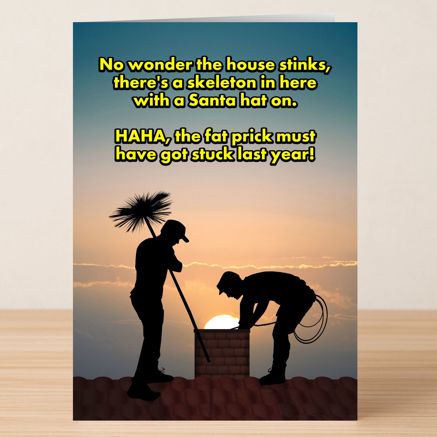 The Got Stuck Funny Christmas Card by Twisted Gifts features two chimney sweeps silhouetted at sunset, with a witty message about finding a skeleton in a Santa hat, perfect for adding festive laughter to the season.