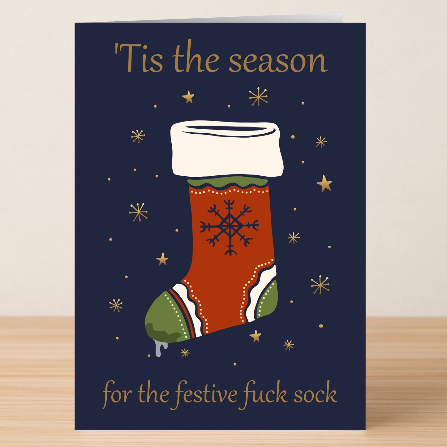 Twisted Gifts' Festive Sock Funny Christmas Card features a red festive sock and snowflake on a dark blue background with gold stars and the text "'Tis the season for the festive fuck sock"—perfect for holiday humor.