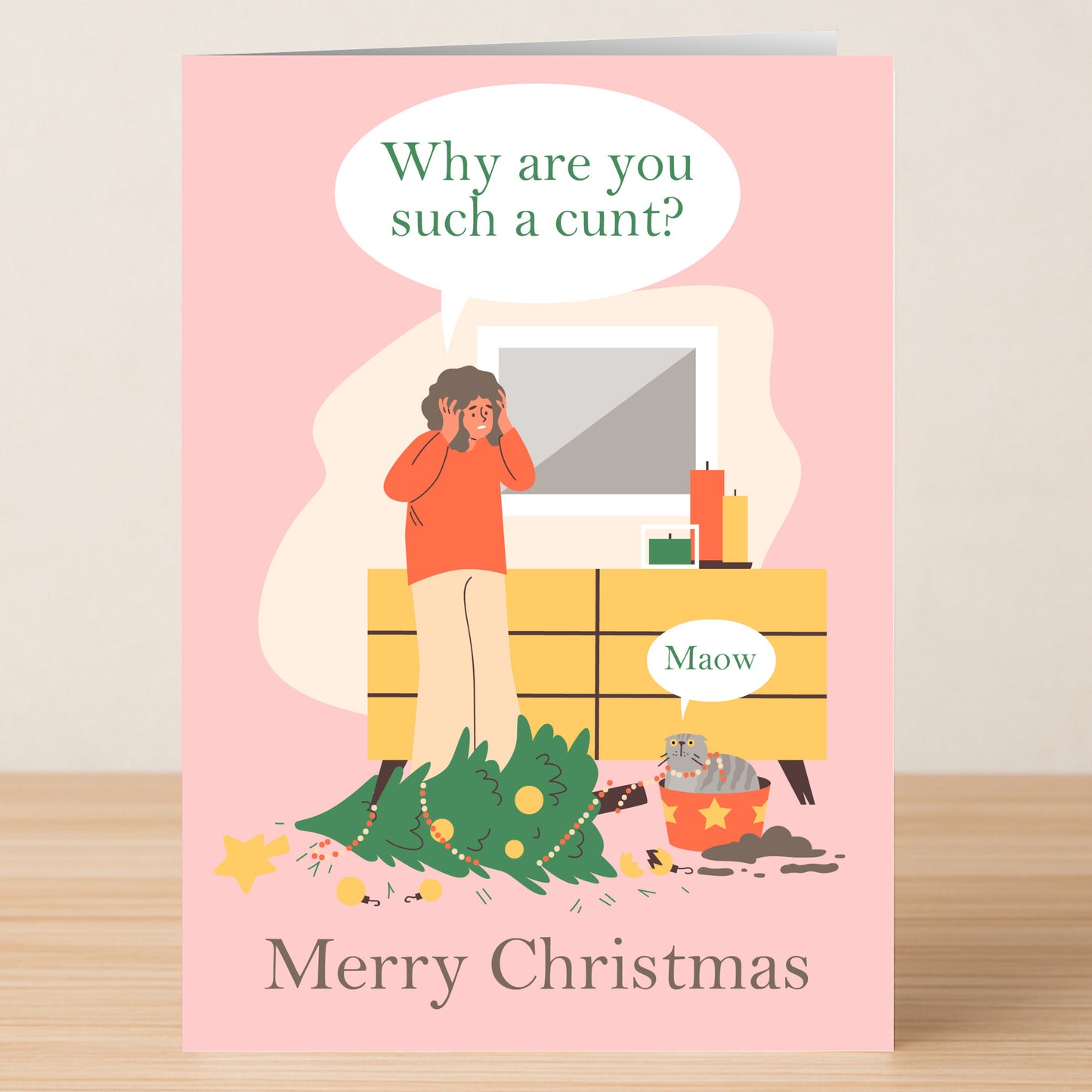 A cartoon on the Maow Funny Christmas Card by Twisted Gifts shows a distressed person beside a toppled tree and mischievous cat. Speech bubble: "Why are you such a cunt?" Cat: "Maow." Text: "Merry Christmas." Perfect for holiday laughs.