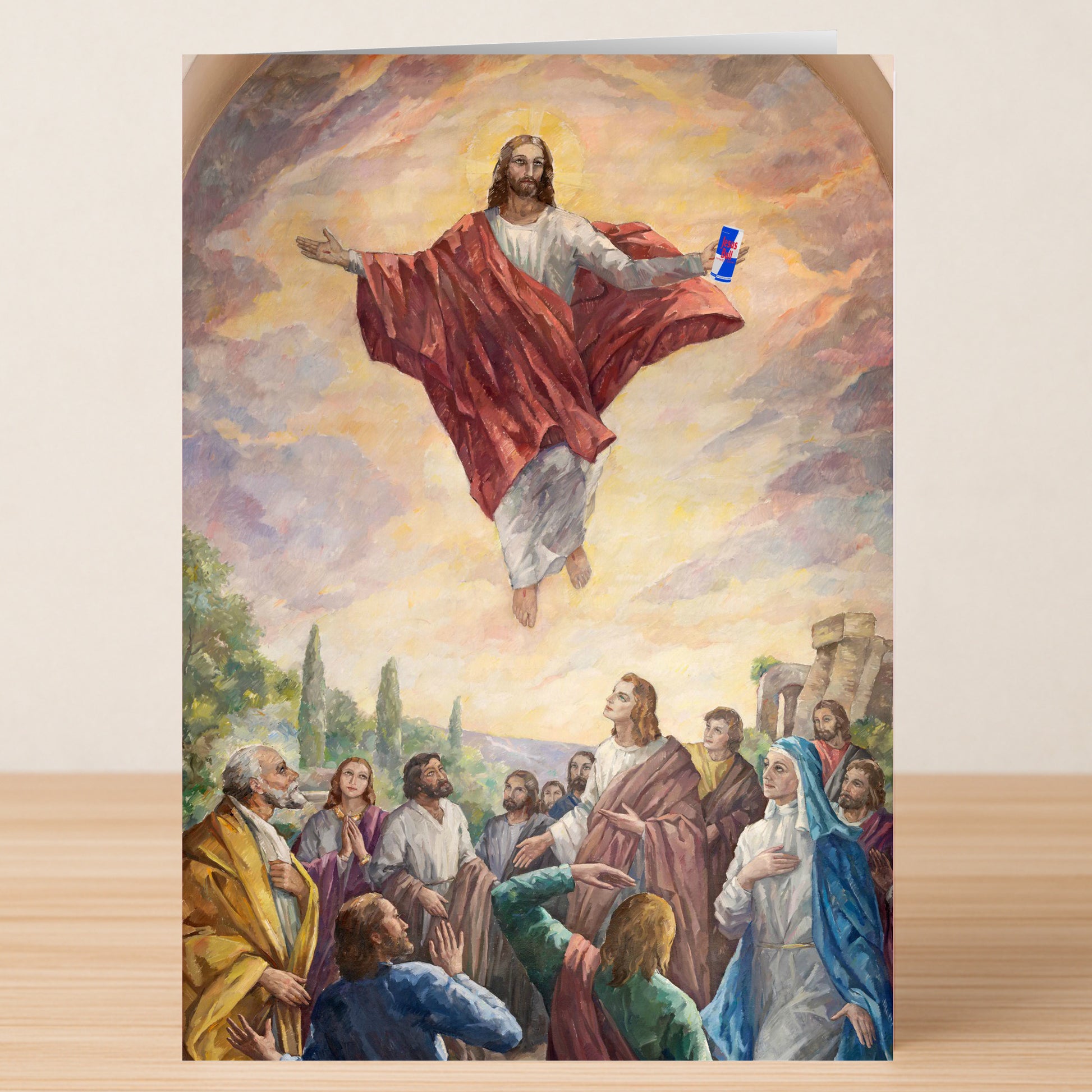 The Jesus Bull Funny Christmas Card by Twisted Gifts features a painting-style image of Jesus ascending with a can of Red Bull, surrounded by disciples—a unique and lighthearted choice for a memorable holiday greeting.