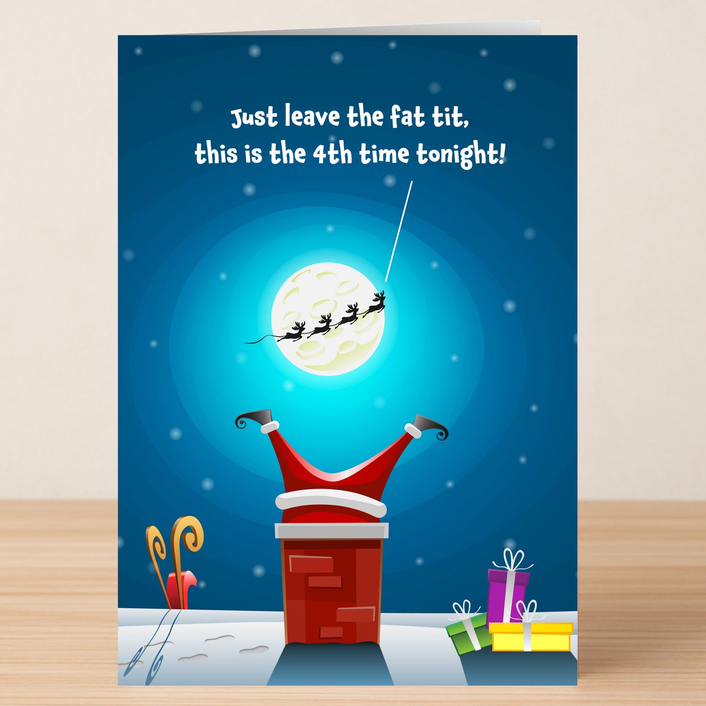 The Fat Tit Christmas Card by Twisted Gifts features a cartoon Santa stuck headfirst in a chimney, legs up, with a speech bubble to his sleigh before the moon—presents on the snowy rooftop add cheeky festive laughs.