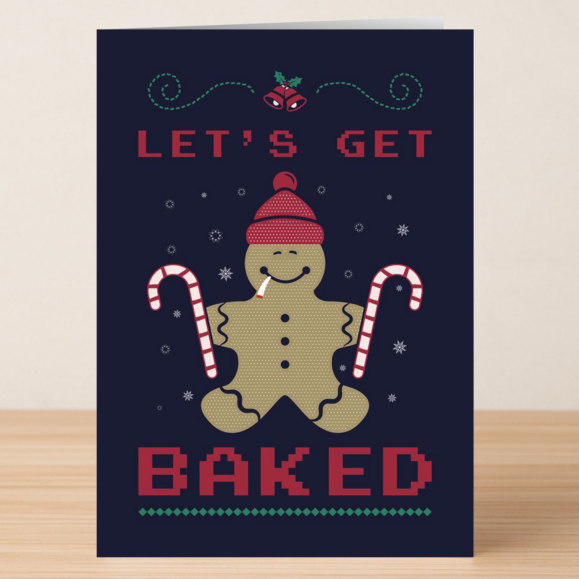 The Baked Funny Christmas Card by Twisted Gifts shows a gingerbread figure with a hat, joint, and candy canes, plus “LET’S GET BAKED” text. Snowflakes and holly add festive cheer to this quirky holiday card.