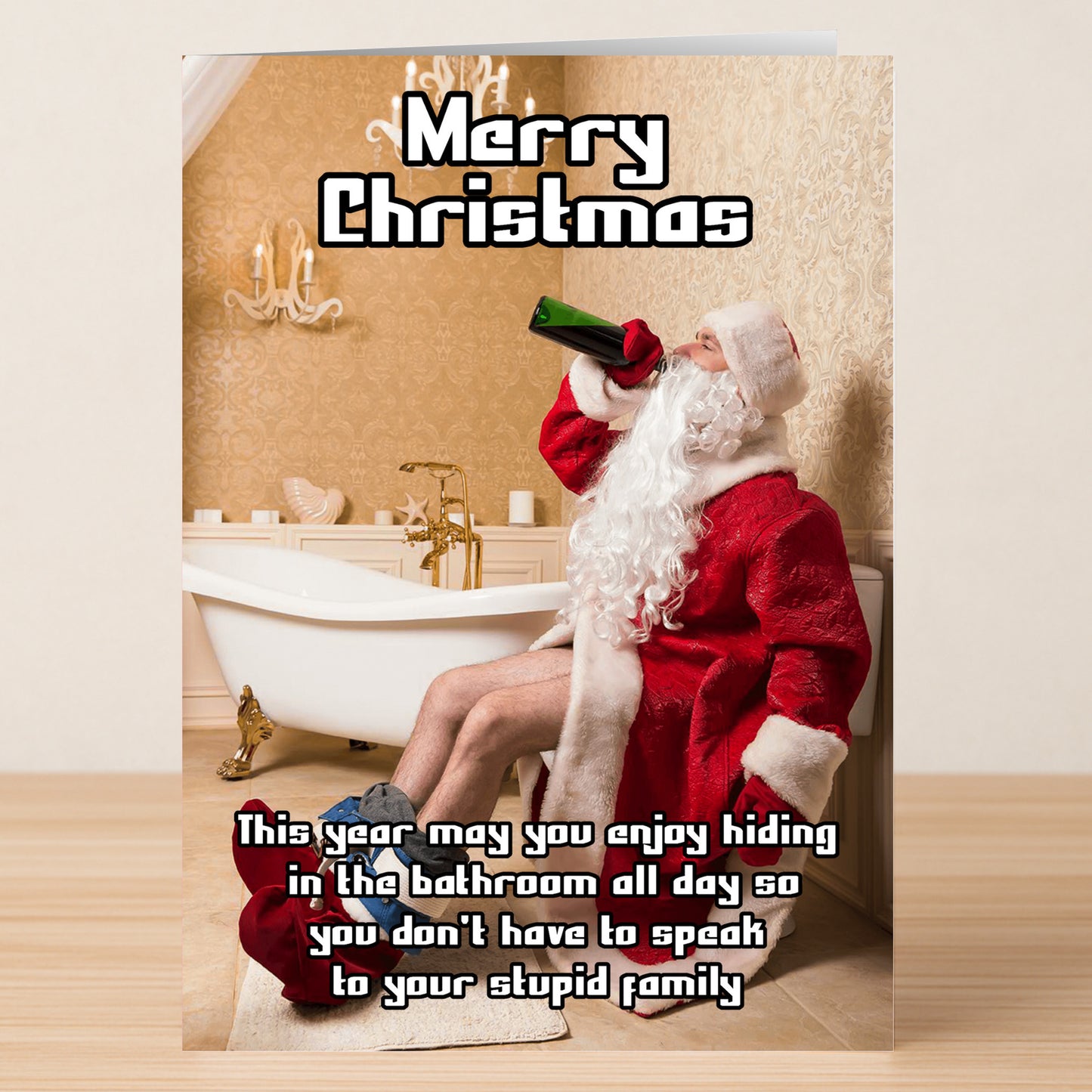 A person in a Santa costume sits on a closed toilet in a bathroom, drinking from a green bottle. Text reads "Merry Christmas." Bathroom Hiding Funny Christmas Card by Twisted Gifts with a humorous holiday message.