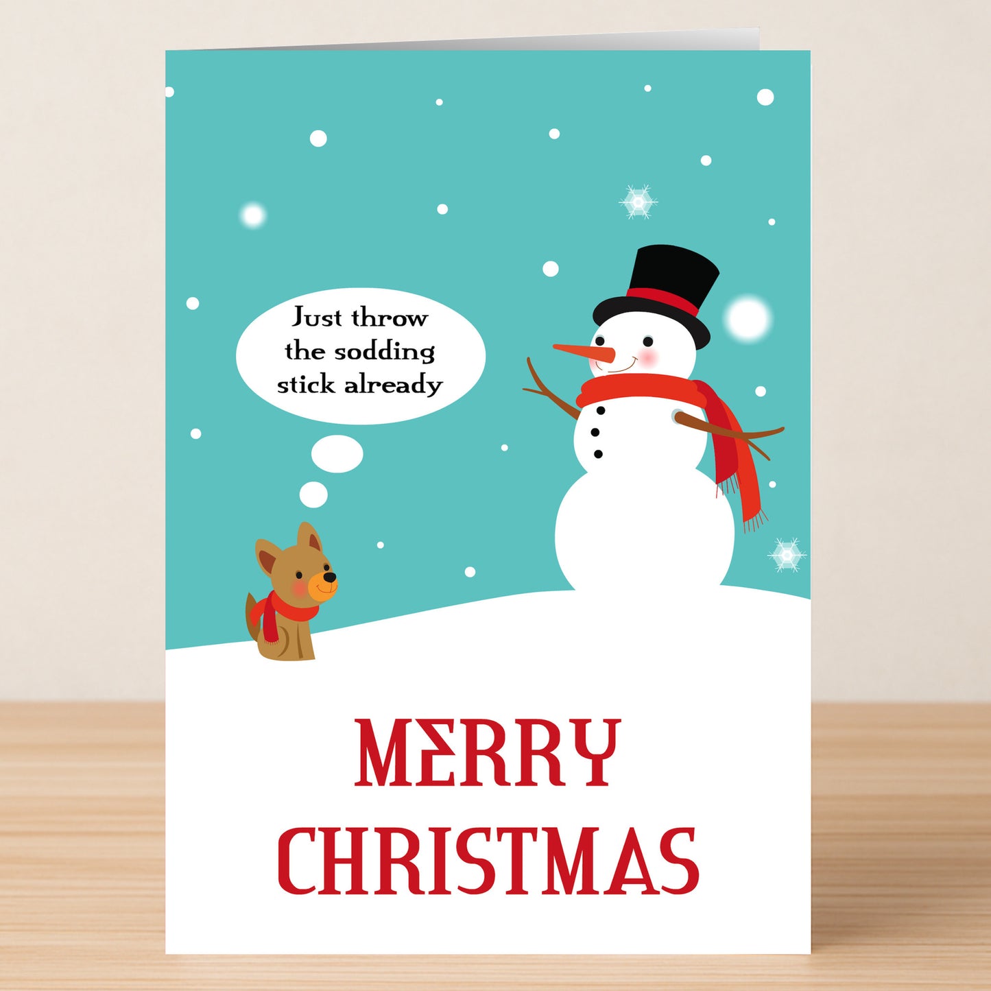 The Sodding Stick Rude Christmas Card by Twisted Gifts features a snowman and dog in the snow with the dog thinking, "Just throw the sodding stick already." A hilarious choice for anyone who loves dog humour. Card reads "Merry Christmas.