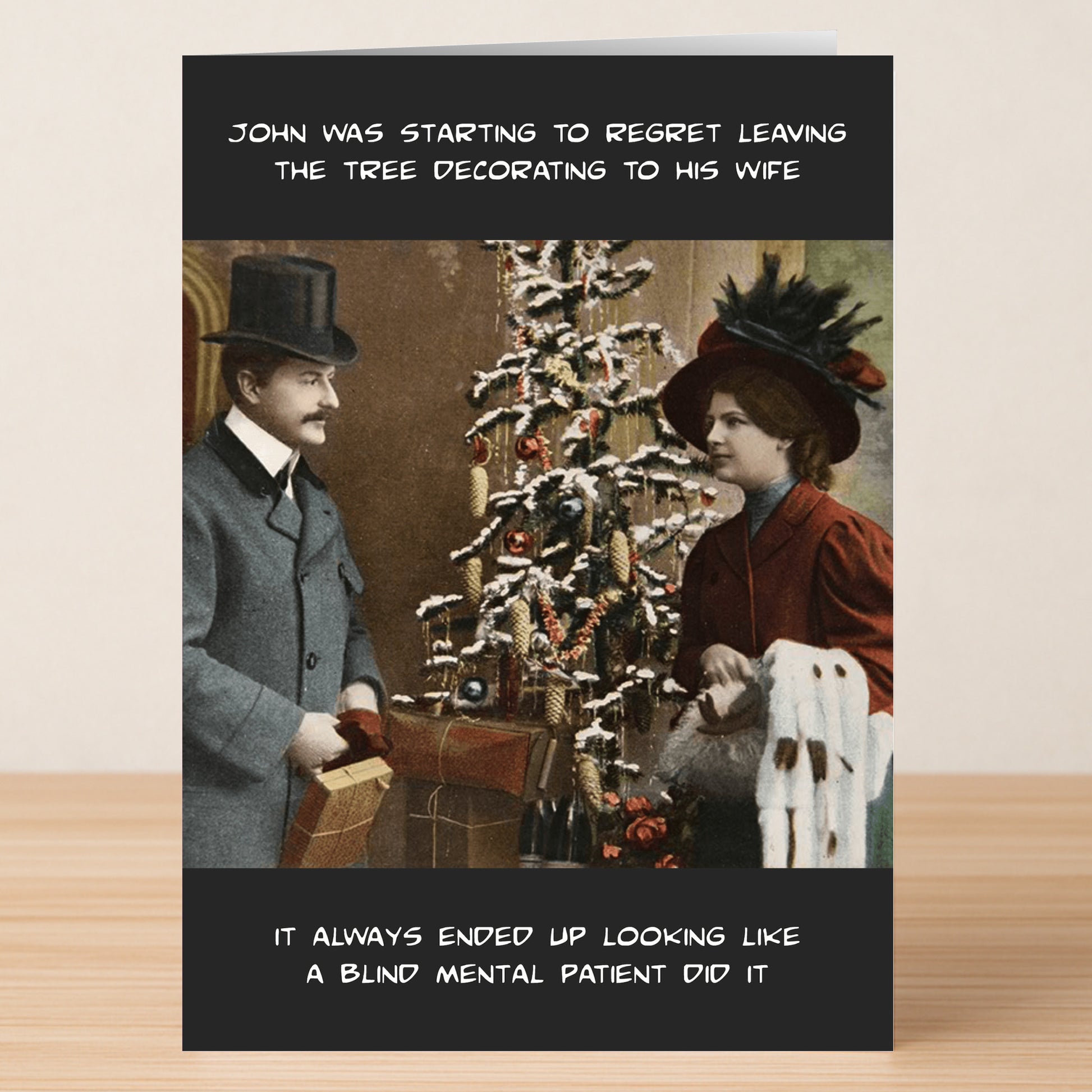 A man and woman in vintage outfits stand by a poorly decorated Christmas tree with gifts; Twisted Gifts’ "Mental Patient Funny Christmas Card" brings humor to holiday disappointment.