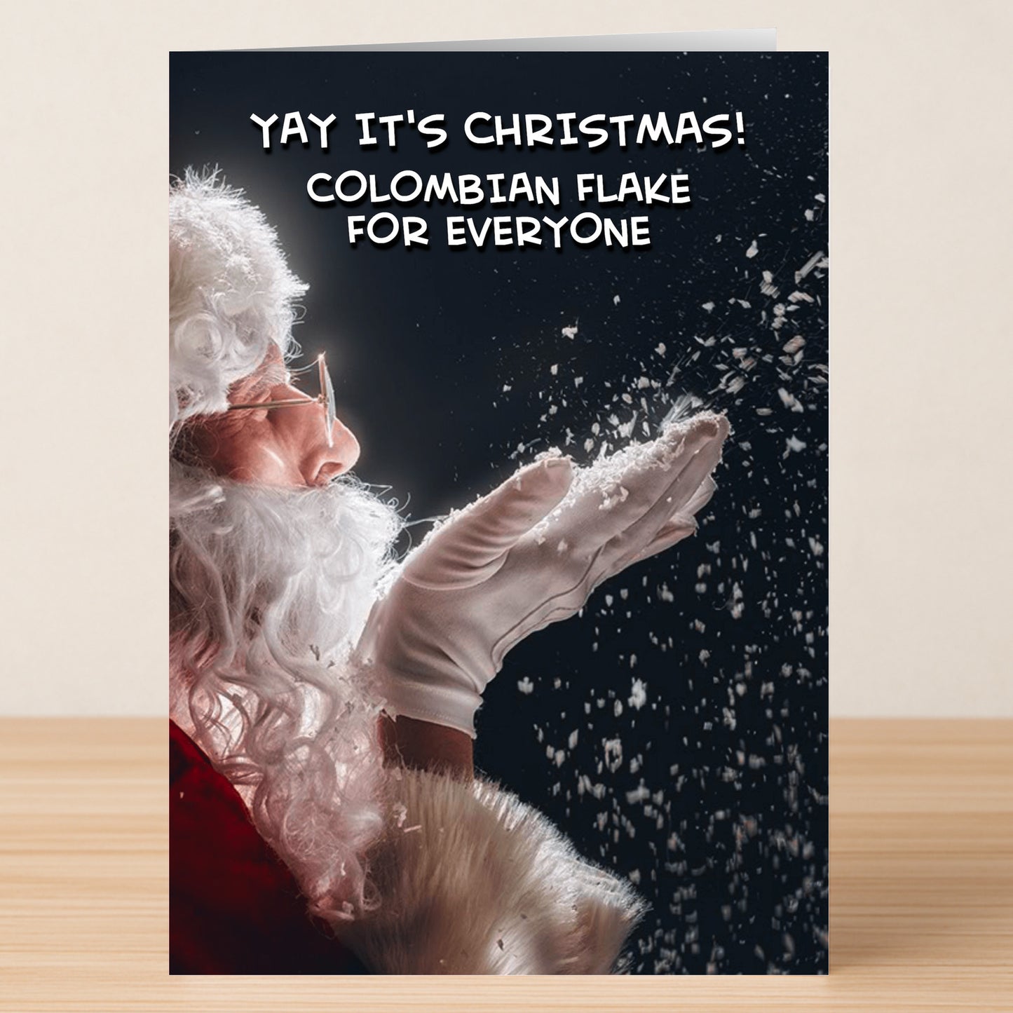 The Colombian – Funny Christmas Card by Twisted Gifts features a Santa blowing white powder and the text "YAY IT'S CHRISTMAS! COLOMBIAN FLAKE FOR EVERYONE." Perfect for anyone who loves edgy, humorous holiday cards.