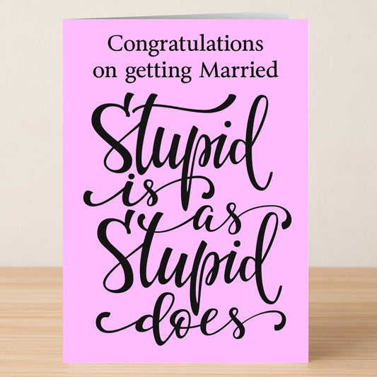 The Stupid Insulting Congratulations Card by Twisted Gifts features bold and cursive black text reading, “Congratulations on getting Married. Stupid is as Stupid does,” adding humor to any celebration. The card is pink.