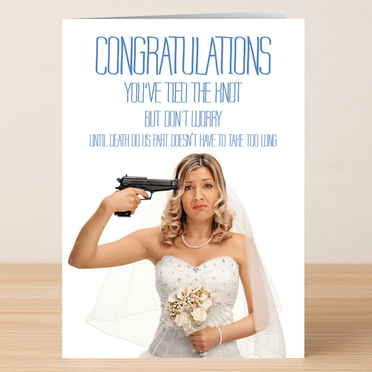 A bride in a wedding dress points a pistol at her head, looking unhappy. The Twisted Gifts Death Do Us Part Funny Congratulations Card delivers dark humor: “Congratulations, you’ve tied the knot… but ‘til death do us part doesn’t have to take too long.”.