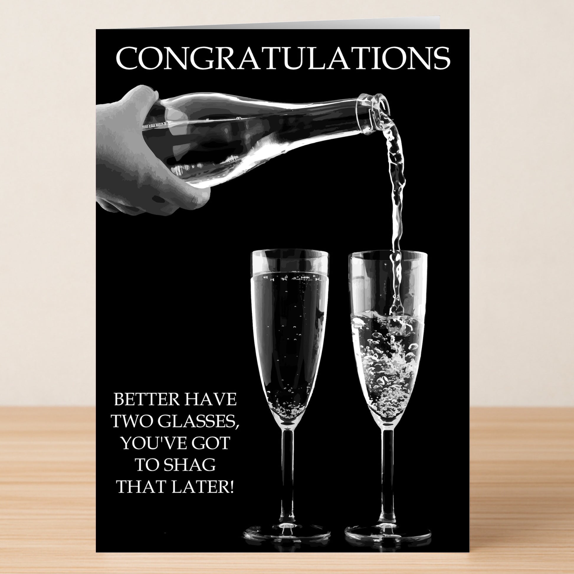 The Two Glasses Insulting Congratulations Card from Twisted Gifts features a hand pouring champagne into one of two glasses with the message: "CONGRATULATIONS" and "Better have two glasses, you've got to shag that later!.