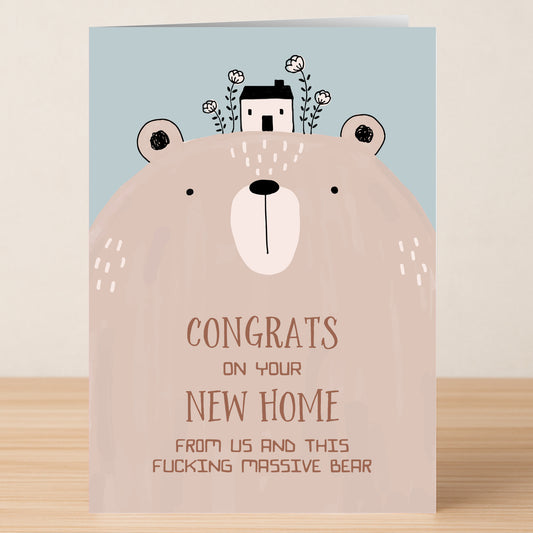 The Massive Bear Funny Congratulations Card by Twisted Gifts features an illustrated bear with a house on its head and the message, "Congrats on your new home from us and this fucking massive bear." A humorous card for welcoming someone.