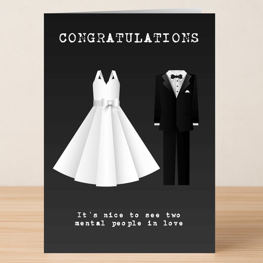 The Mental Insulting Congratulations Card by Twisted Gifts features a wedding dress and tuxedo with "CONGRATULATIONS" and the cheeky line, "It's nice to see two mental people in love." A perfect funny card for couples!.