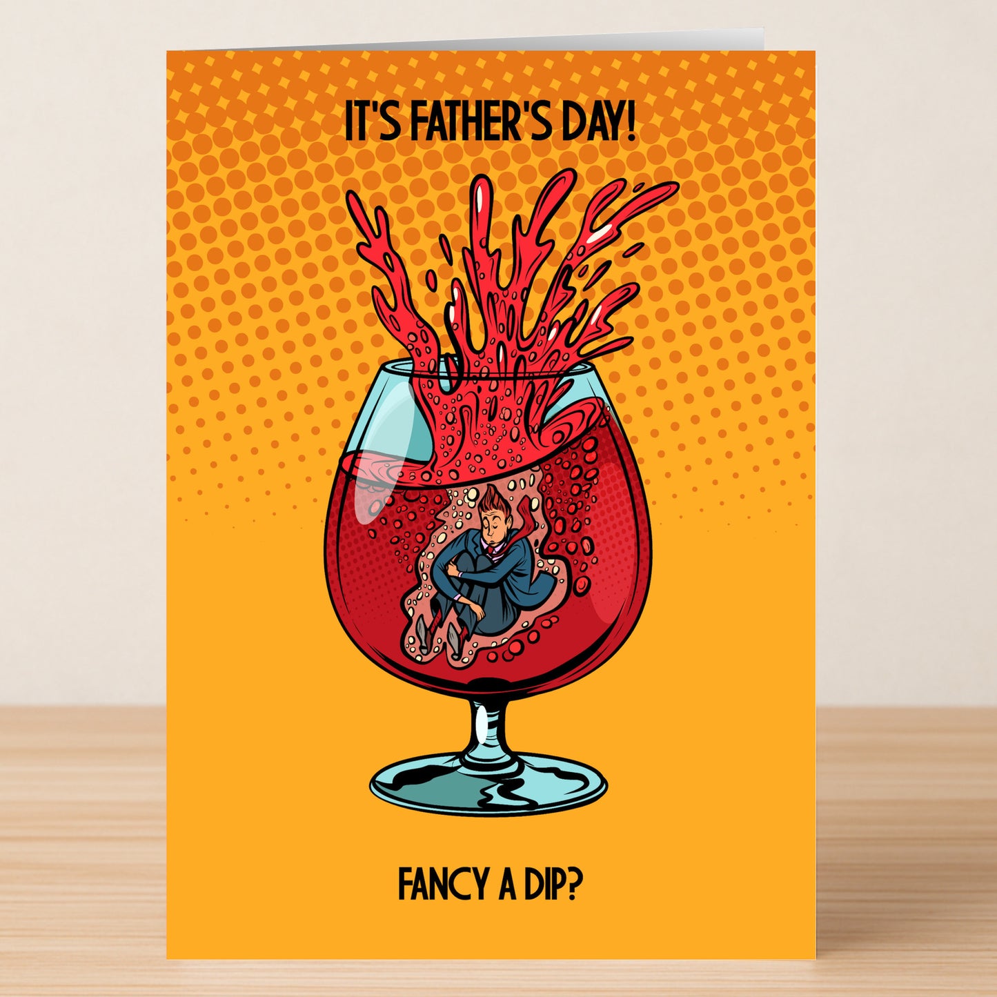 The Fancy A Dip Funny Father's Day Card by Twisted Gifts features a man in a splashing glass of red liquid and the message "IT'S FATHER'S DAY! FANCY A DIP?" on an orange dotted background.