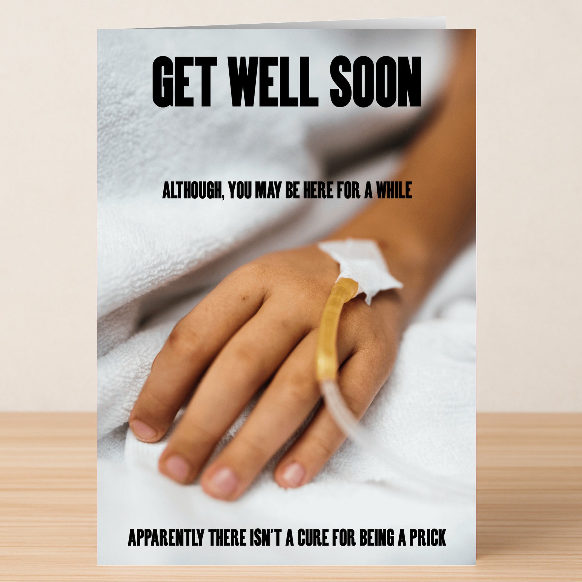 The "Here For A While Rude Get Well Soon Card" by Twisted Gifts features a hand with an IV drip on a blanket and bold text: "Get well soon. Although you may be here for a while. Apparently there isn't a cure for being a prick.