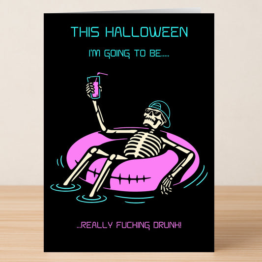 The Really Drunk Funny Halloween Card by Twisted Gifts features a skeleton in sunglasses on a pink pool float with a drink. The card reads, "This Halloween I'm going to be... really fucking drunk!.