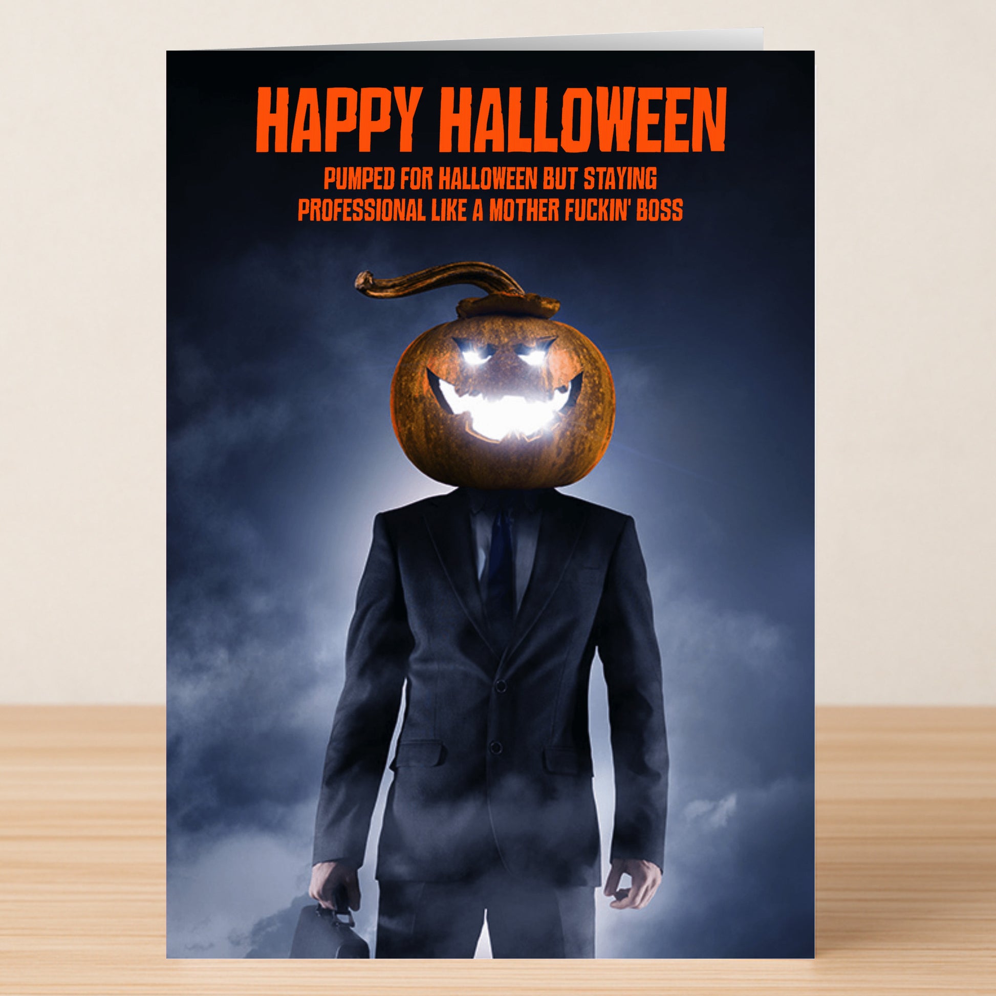 A man in a suit with a glowing pumpkin head holds a briefcase. Text above: "Happy Halloween. Stay professional this spooky season Like A Boss." Like A Boss Funny Halloween Card by Twisted Gifts.