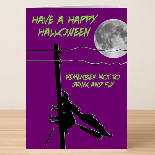 The Drink And Fly Funny Halloween Card by Twisted Gifts features a person on a broomstick balancing on a power line—ideal for sending spooky wishes and laughs this Halloween!.
