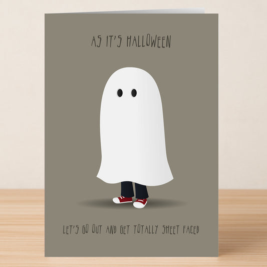The Sheet Faced Funny Halloween Card by Twisted Gifts features a person in a ghost costume with red sneakers and the text "AS IT'S HALLOWEEN LET'S GO OUT AND GET TOTALLY SHEET FACED." A witty choice to send laughs!.