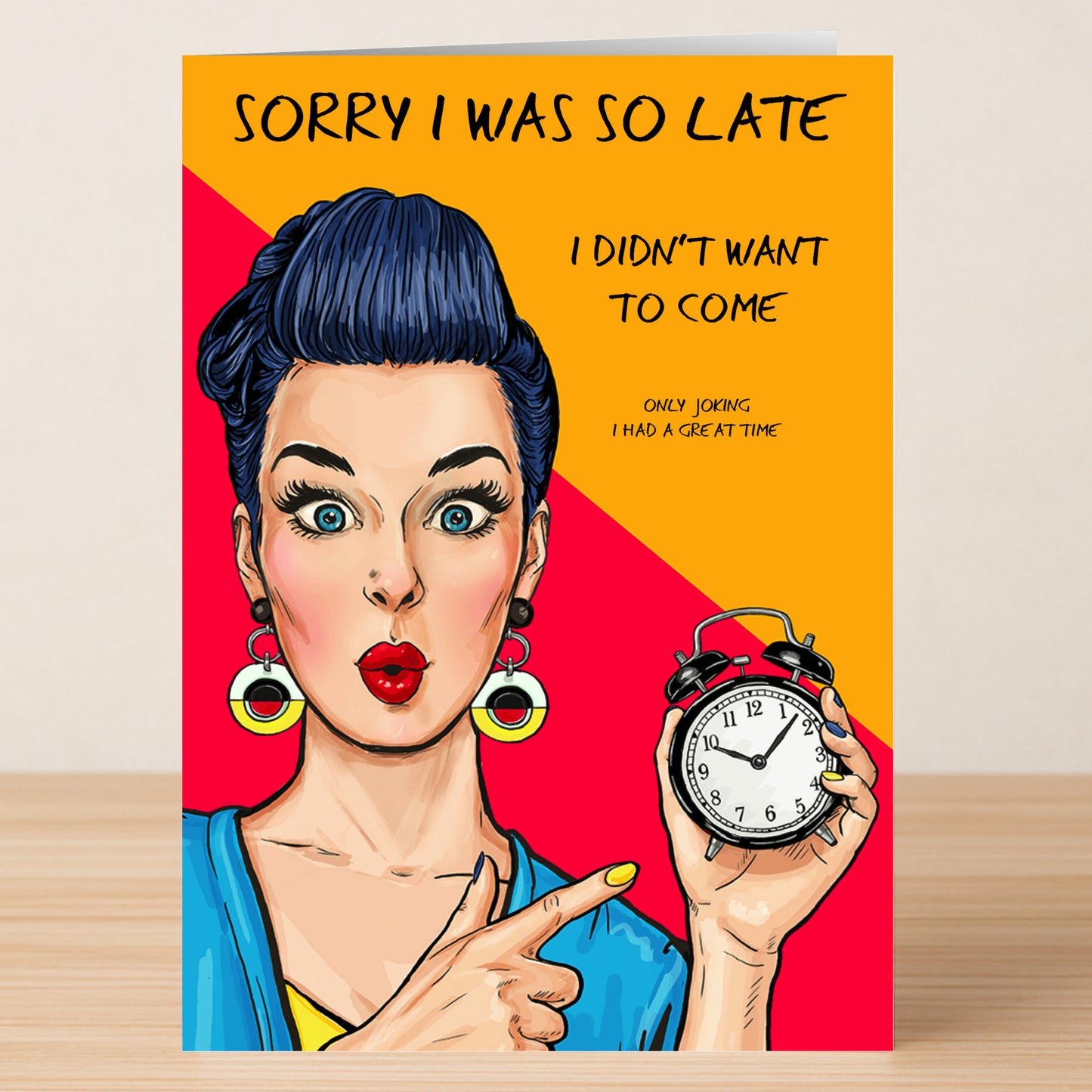 The "Didn't Want To Come – Funny Sorry Card" by Twisted Gifts features a cartoon woman with blue hair and earrings pointing at an alarm clock with the text: "Sorry I was so late. I didn't want to come. Only joking. I had a great time." Perfect for sarcasm lovers!.
