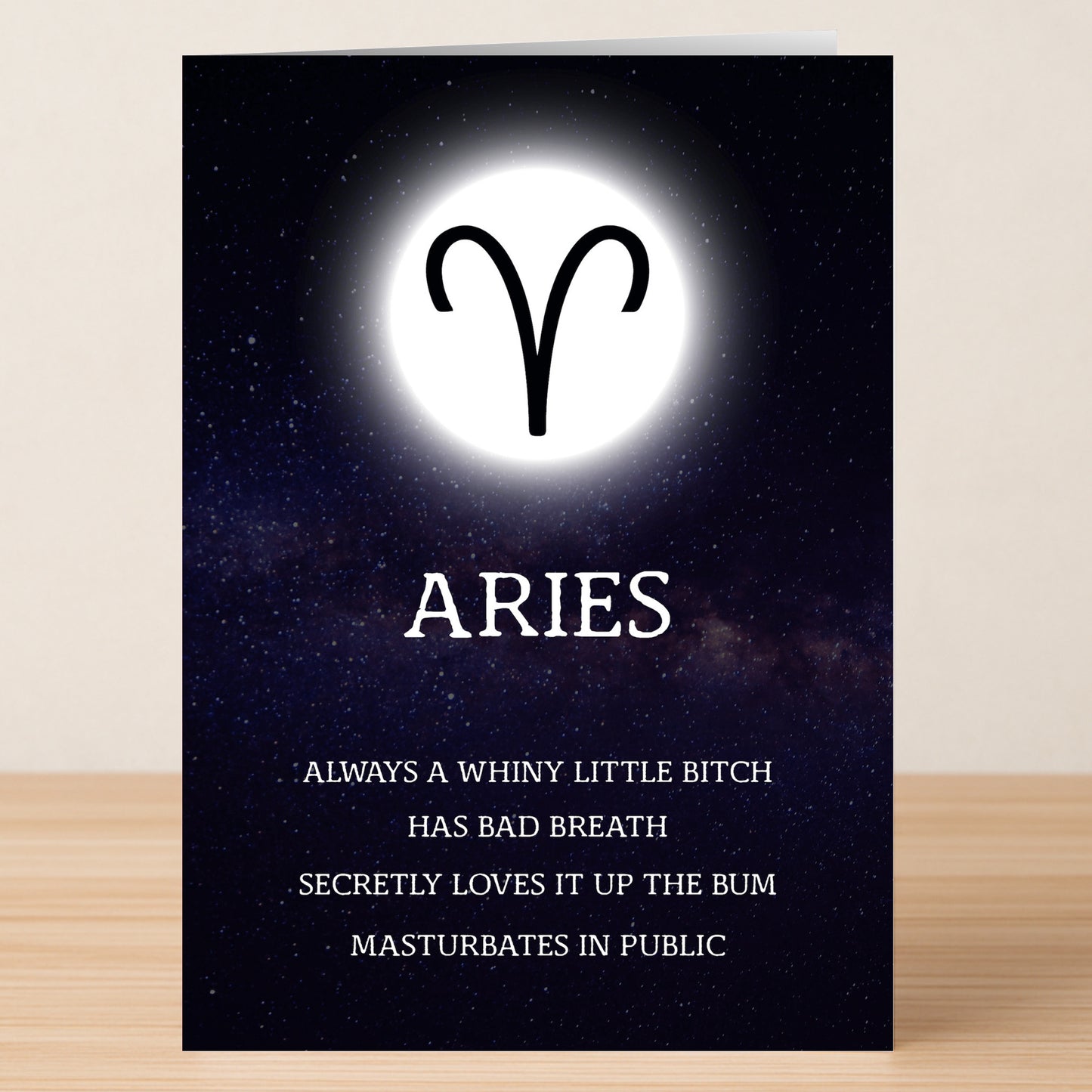 The Aries Rude Star Sign Card by Twisted Gifts features the Aries symbol, "Aries" text, and blunt descriptions of Aries traits and flaws against a starry night sky background.