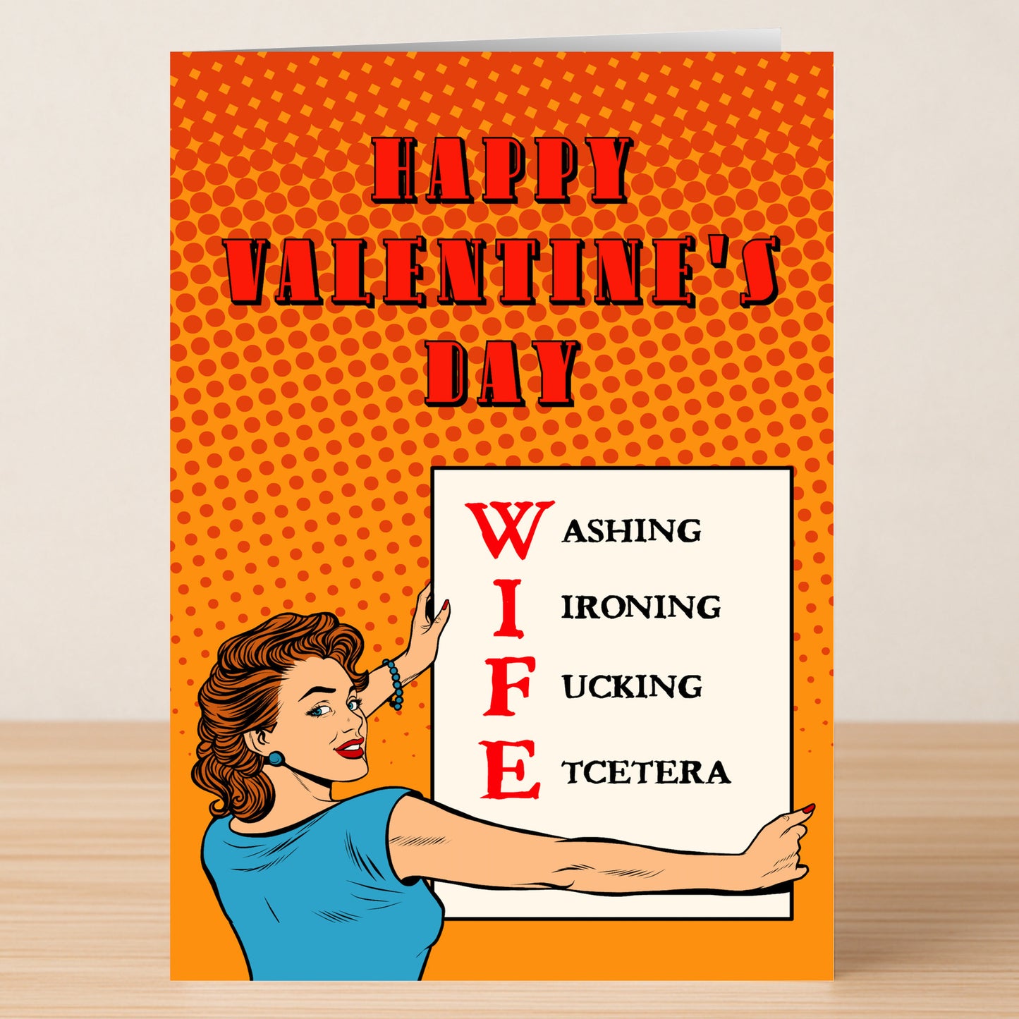 The Wife Funny Valentine’s Card by Twisted Gifts features a woman pointing to a sign where "WIFE" stands for Washing, Ironing, F*cking, Etcetera—ideal as a humorous valentine's card for couples.