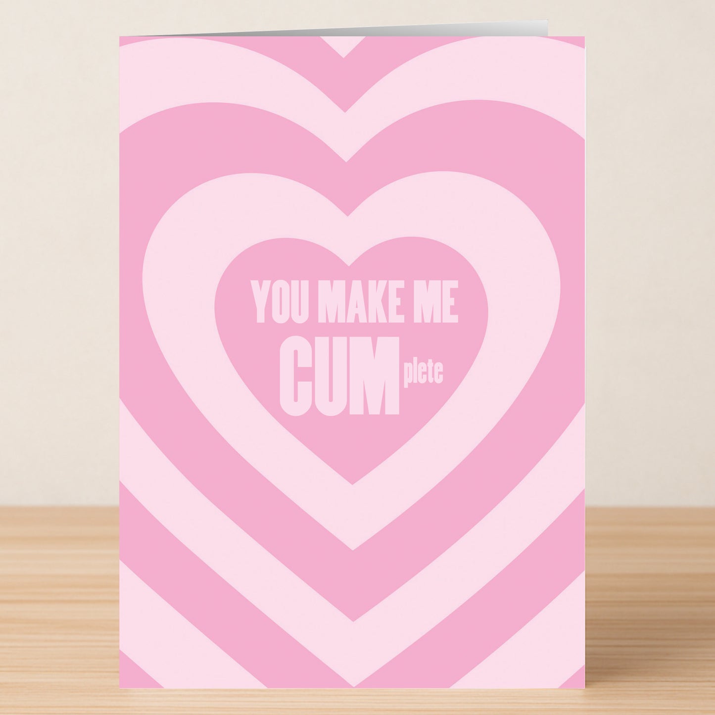 The Cumplete Rude Valentines Card by Twisted Gifts features concentric pink hearts and "YOU MAKE ME CUMplete" in bold white letters—ideal for anyone with a quirky sense of humor.