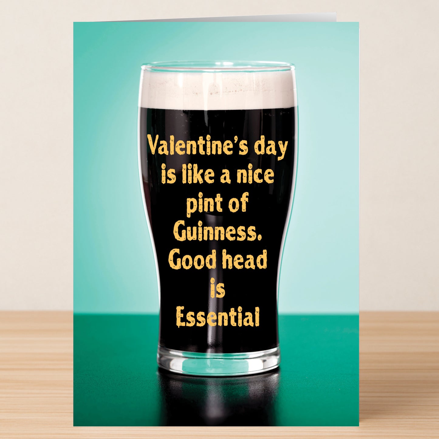 The Good Head Valentines Card by Twisted Gifts features a pint of Guinness with "Valentine’s day is like a nice pint of Guinness. Good head is Essential" printed on the glass, set on a teal background—a funny Valentine’s card.