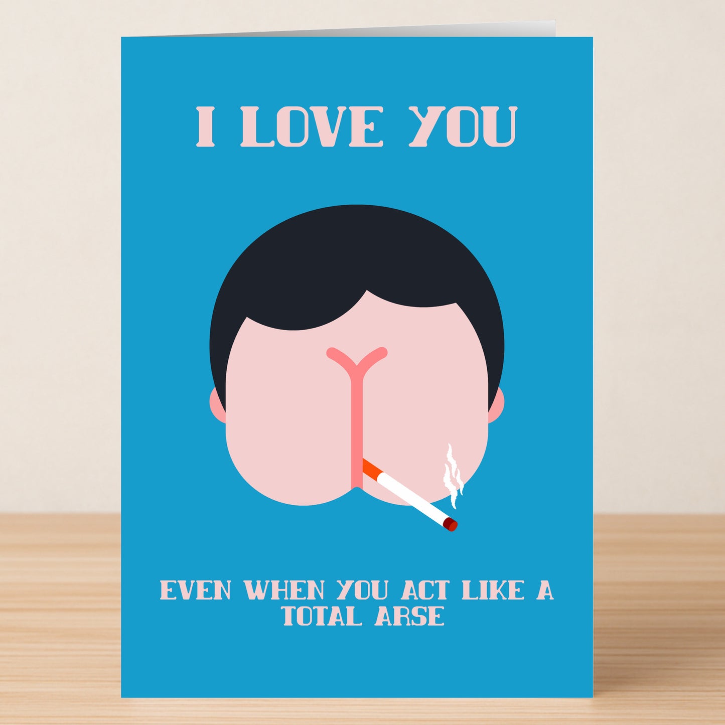 The Total Arse Insulting Greeting Card by Twisted Gifts features "I LOVE YOU" above a cartoon butt with a cigarette, and "EVEN WHEN YOU ACT LIKE A TOTAL ARSE" below—perfect for Valentine’s Day.