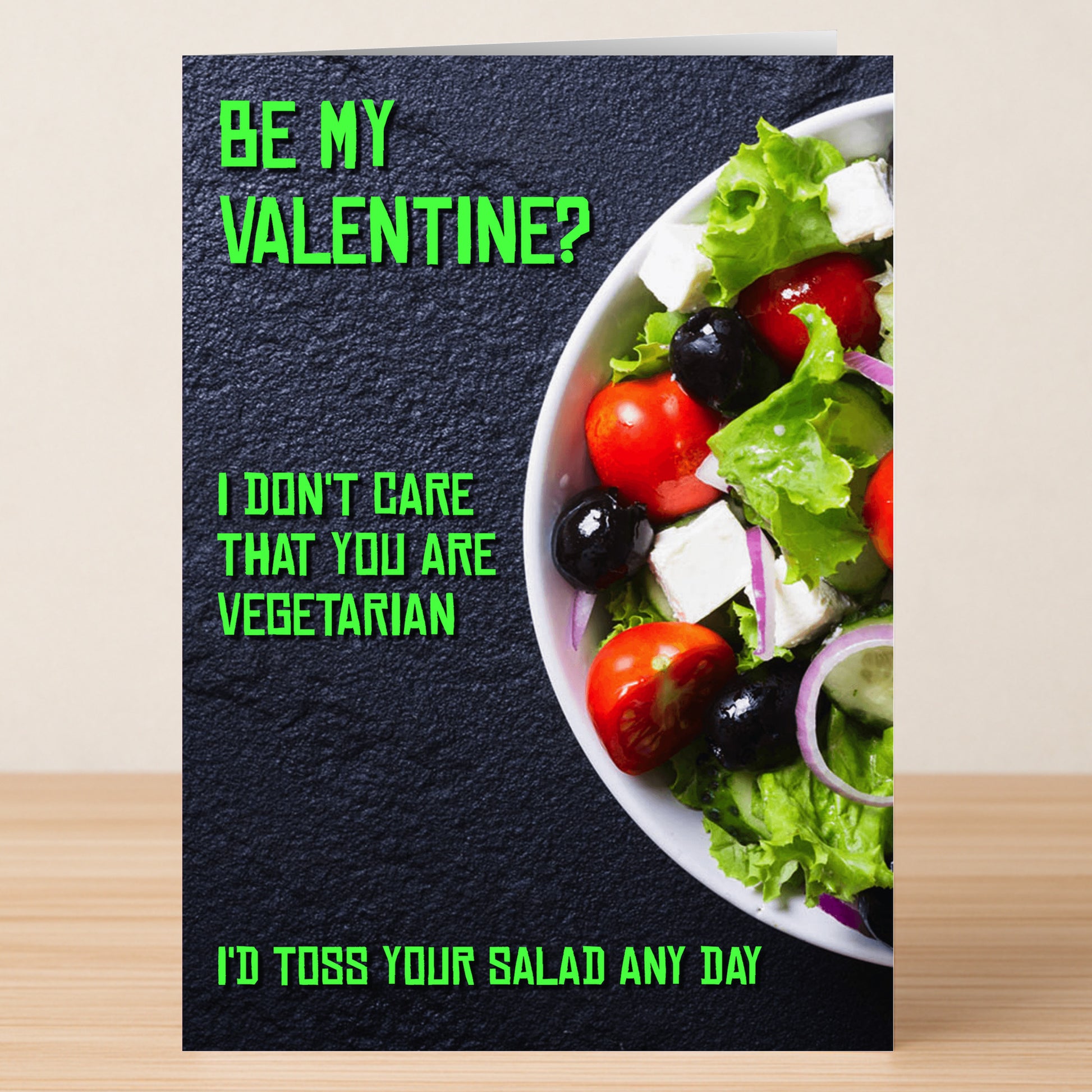 The Toss Your Salad Rude Valentine's Card by Twisted Gifts is a cheeky card for playful couples, featuring a salad bowl and green text: “Be my Valentine? I don’t care that you are vegetarian. I’d toss your salad any day.”.