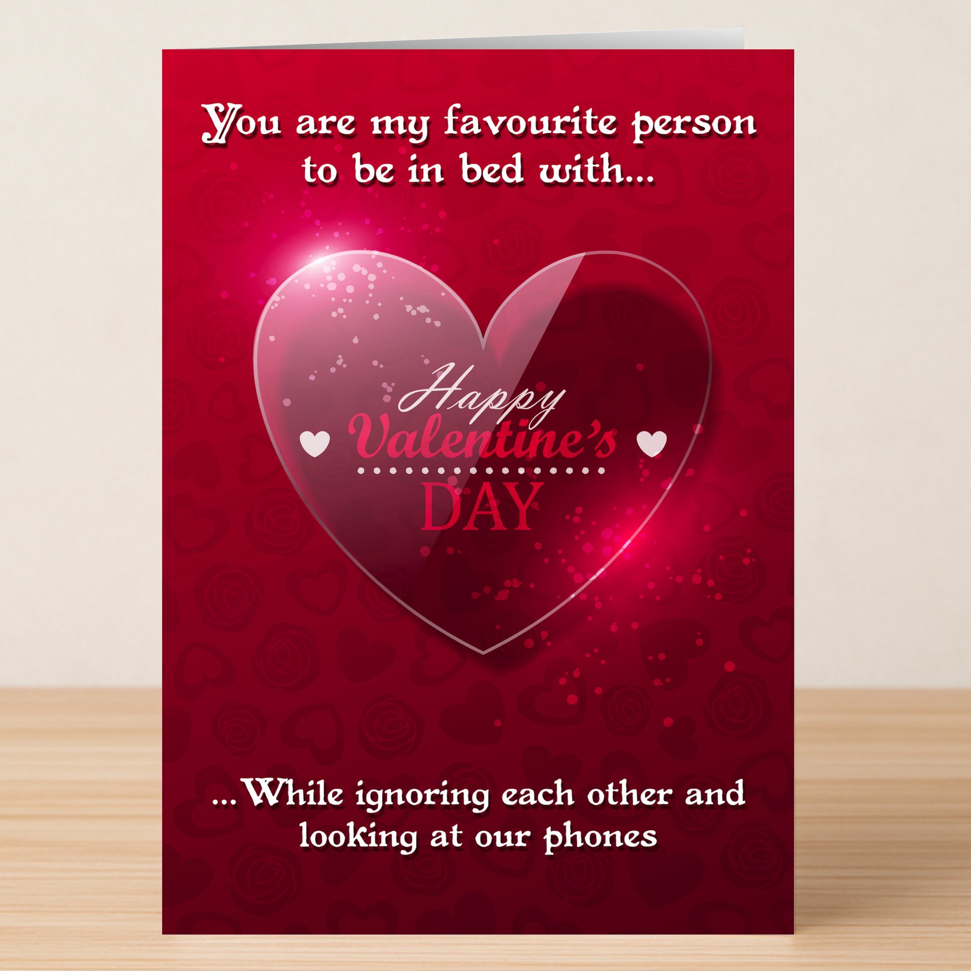 The Phones Funny Valentine's Card by Twisted Gifts features a heart graphic and the text: "You are my favourite person to be in bed with... While ignoring each other and looking at our phones." A witty choice for tech-loving couples!.