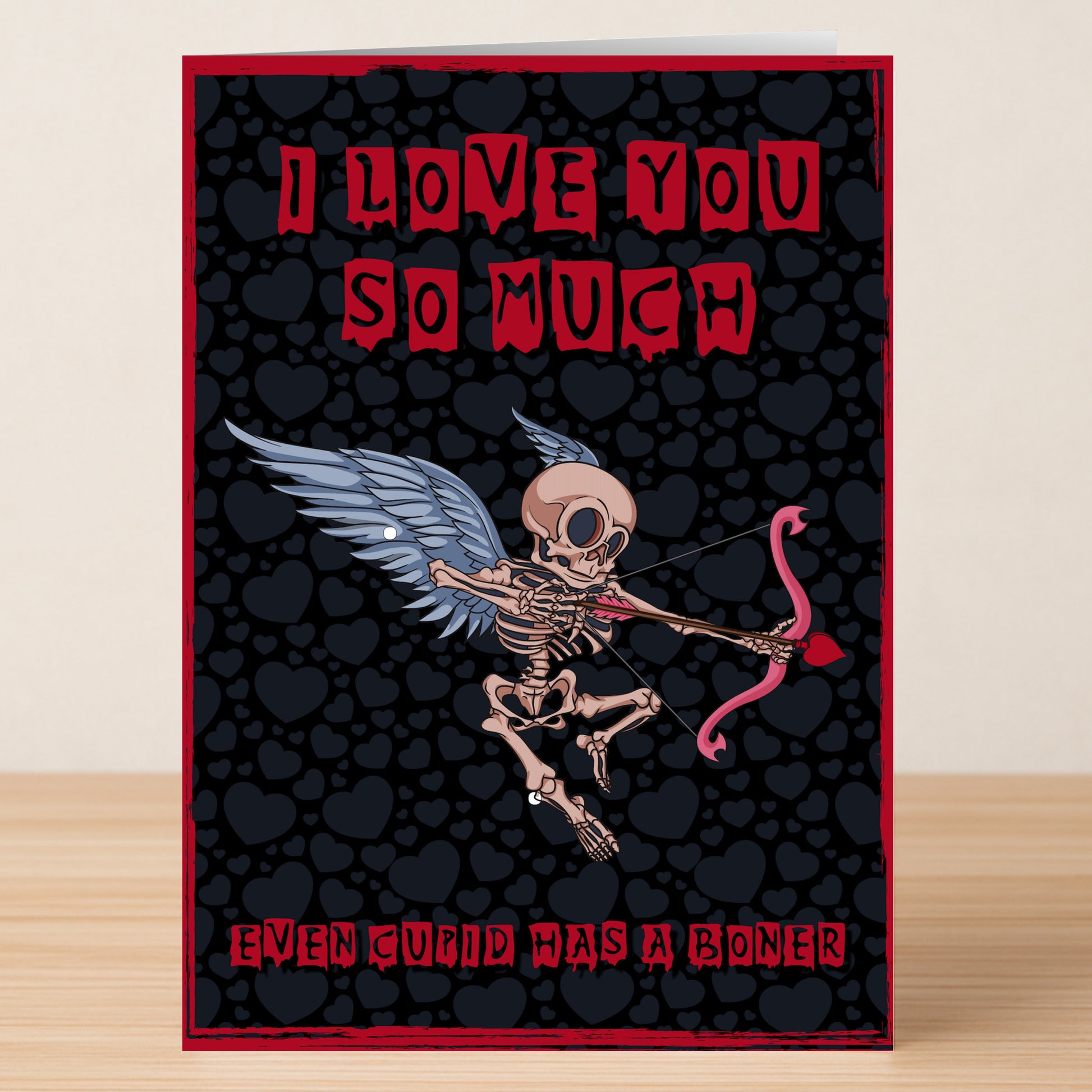 Surprise with the Cupid Funny Valentine's Card by Twisted Gifts! Features a winged skeleton Cupid and hearts, plus funny text: "I LOVE YOU SO MUCH" and "EVEN CUPID HAS A BONER." Perfect for those who love humor!.