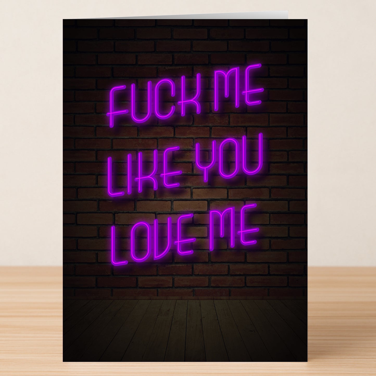 The Like You Love Me Rude Valentine's Card by Twisted Gifts features "FUCK ME LIKE YOU LOVE ME" in bright pink neon-style text on a dark brick wall—ideal for someone with a bold, cheeky sense of humor this Valentine's Day.