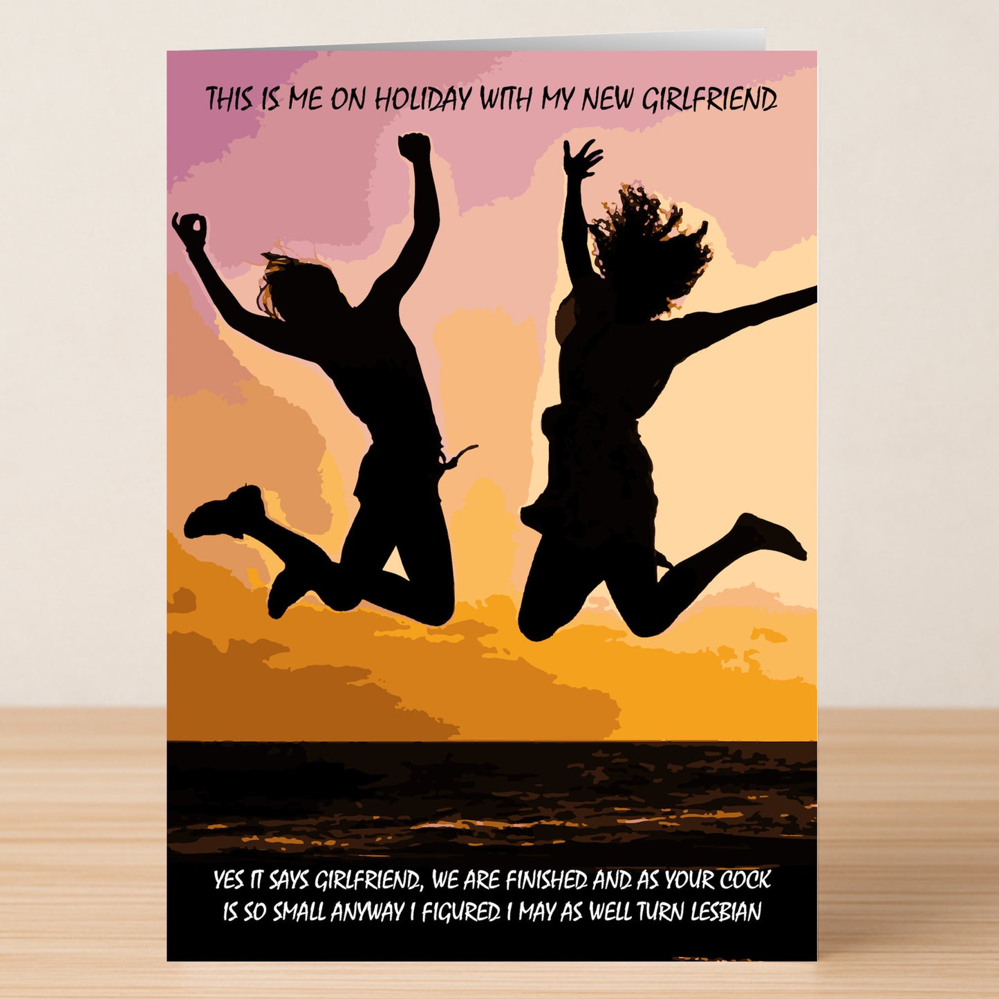 Two people leap at sunset with the "Turn Lesbian Insulting You're Dumped Card" by Twisted Gifts, showcasing a humorous breakup message about holidaying with a new girlfriend and playfully moving on after splitting up.