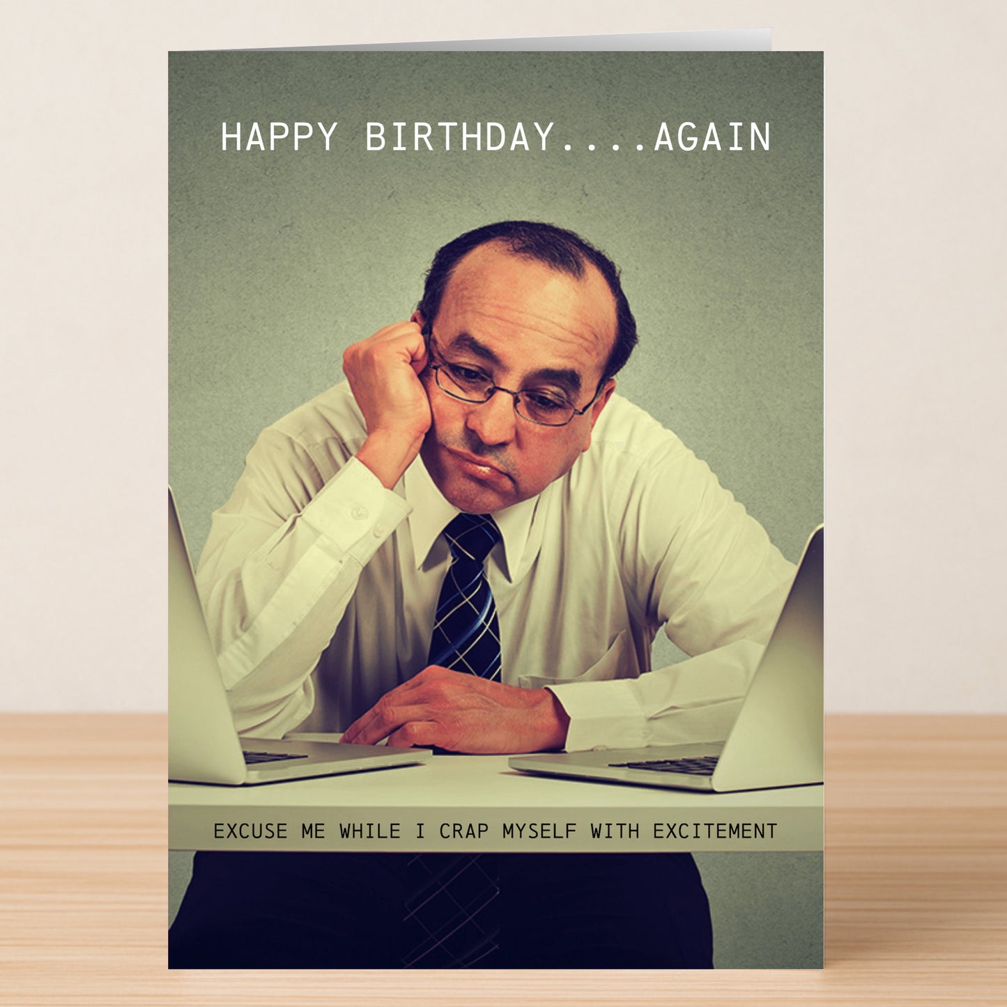 The Excitement – Funny Birthday Card by Twisted Gifts shows a man in a shirt and tie, bored between two laptops. The card reads, "HAPPY BIRTHDAY....AGAIN" and "EXCUSE ME WHILE I CRAP MYSELF WITH EXCITEMENT.